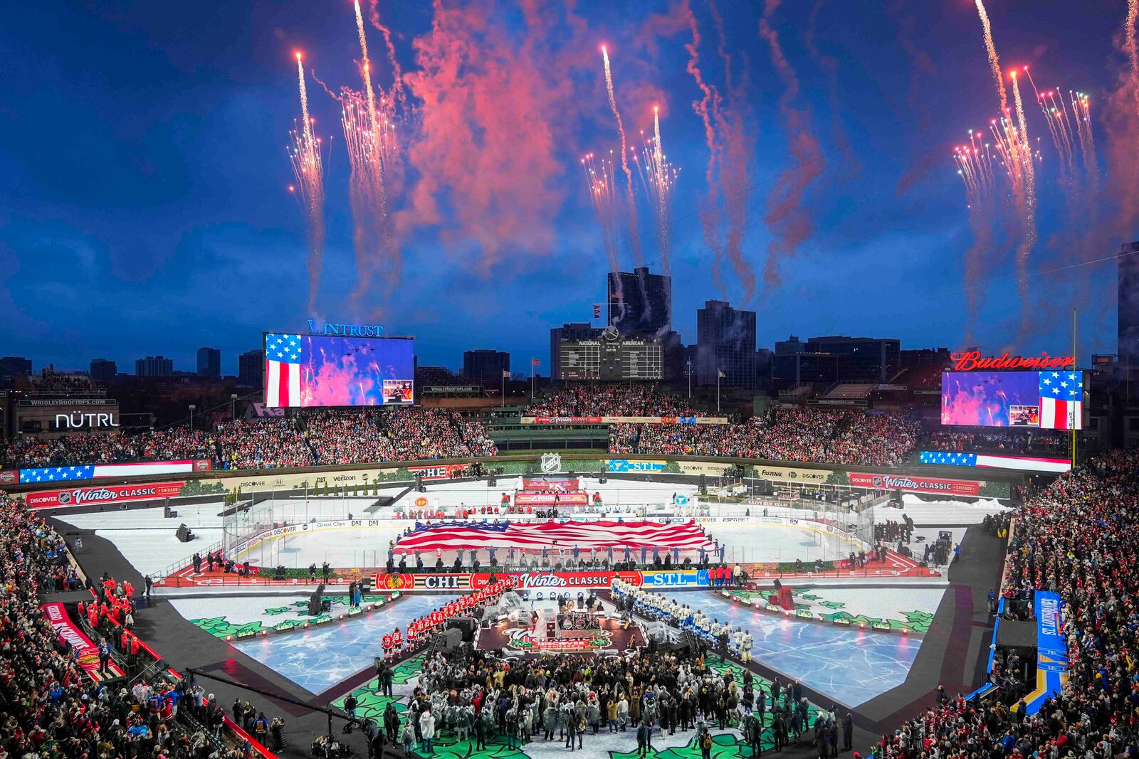 Fireworks explode during the Star-Spangled Banner before the NHL Winter Classic outdoor hockey game featuring the Chicago Blackhawks and St. Louis Blues at Wrigley Field, Tuesday, Dec. 31, 2024, in Chicago. (AP Photo/Erin Hooley)