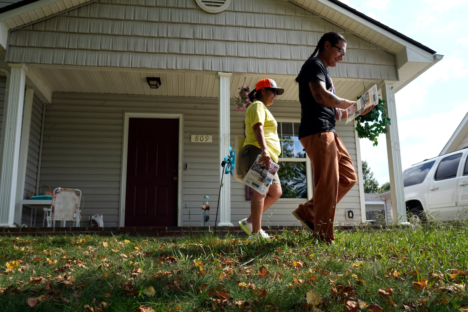 Salvador Fonseca, right, and Elena Jimenez leave a home during a voter engagement event for the Latino community in Greensboro, N.C., Saturday, Sept. 21, 2024. (AP Photo/Chuck Burton)