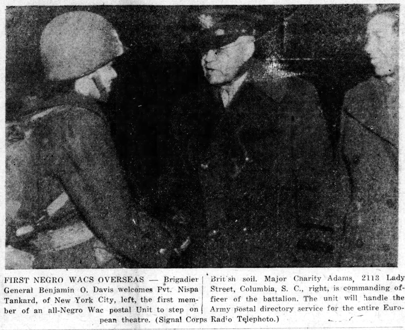 Brigadier General Benjamin O. Davis welcomes Private Nispa Tankard of New York City, left of the Wac postal unit to Europe in 1945.. Major Charity Adams, right, is commanding officer of the battalion. SIGNAL CORPS RADIO PHOTO.