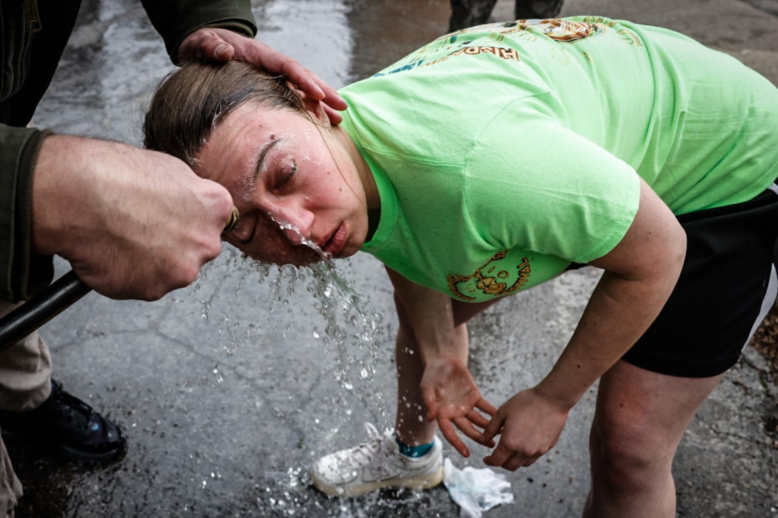 Dayton Daily News reporter, London Bishop is sprayed off after being exposed to pepper spray Saturday during the Sinclair police academy class. JIM NOELKER/STAFF