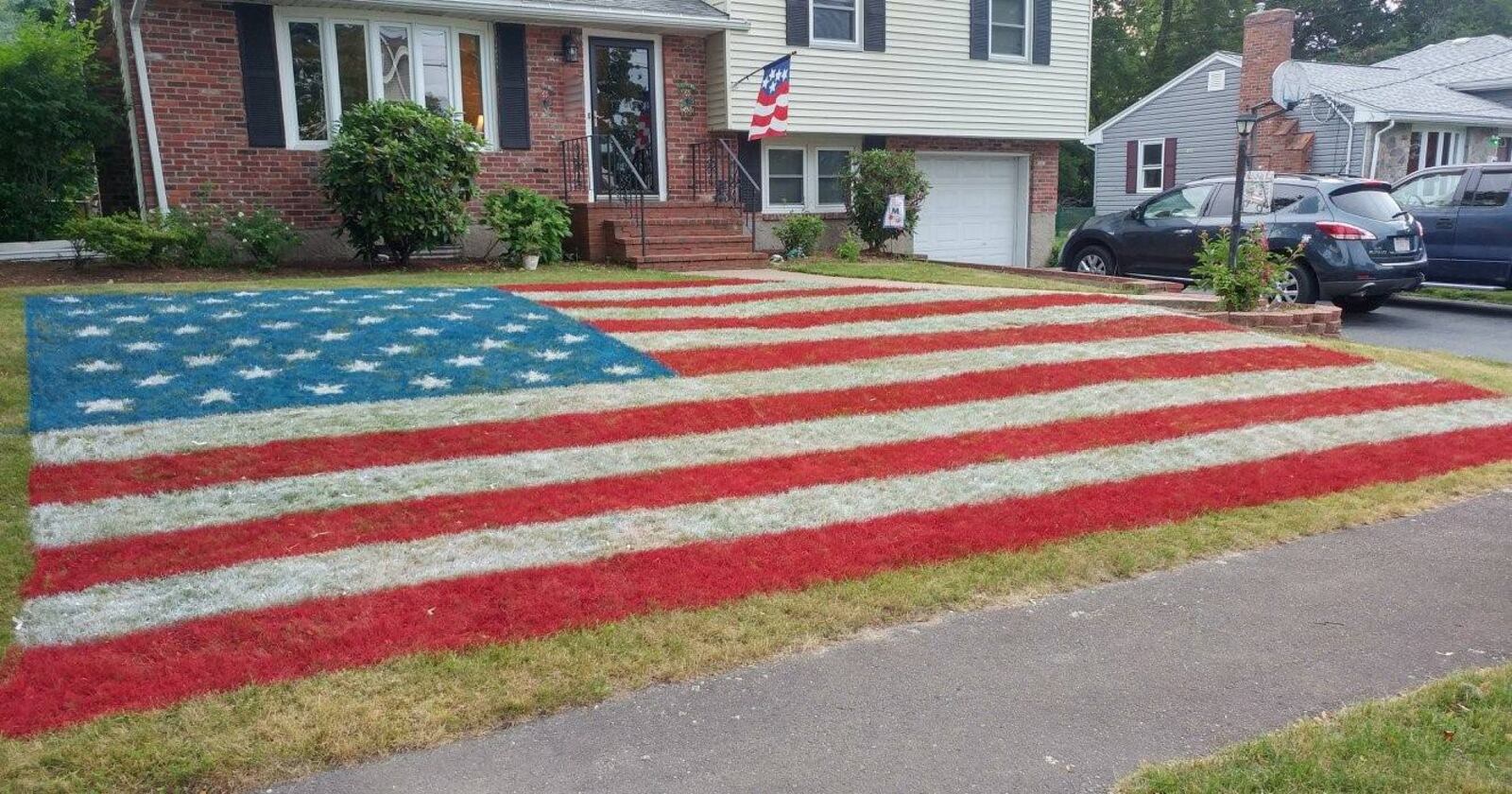 Arthur McCann's tribute to veterans takes up most of the front lawn of his Norwood, Massachusetts, home: A giant American flag, spray-painted using field paint.