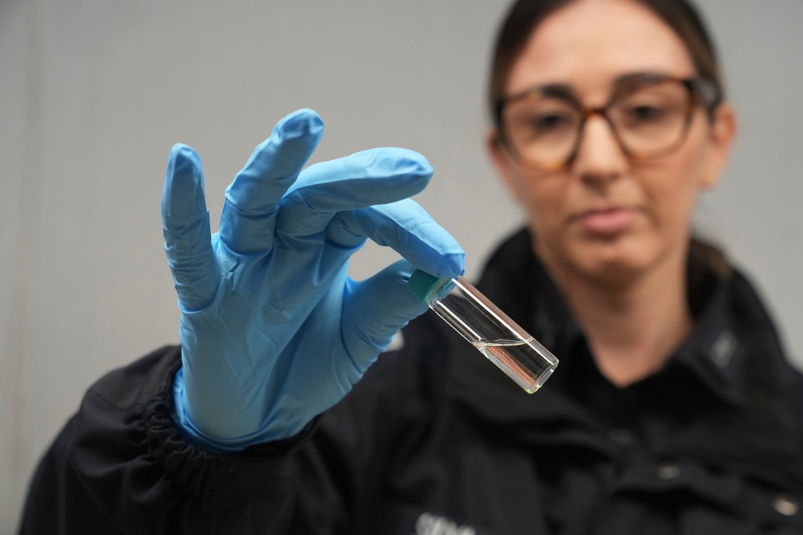 U.S. Customs and Border Protection agriculture specialist Shirley Silva looks at a test tube with an insect larvae she found in a box of roses Friday, Feb. 7, 2025, at Miami International Airport in Miami. (AP Photo/Marta Lavandier)