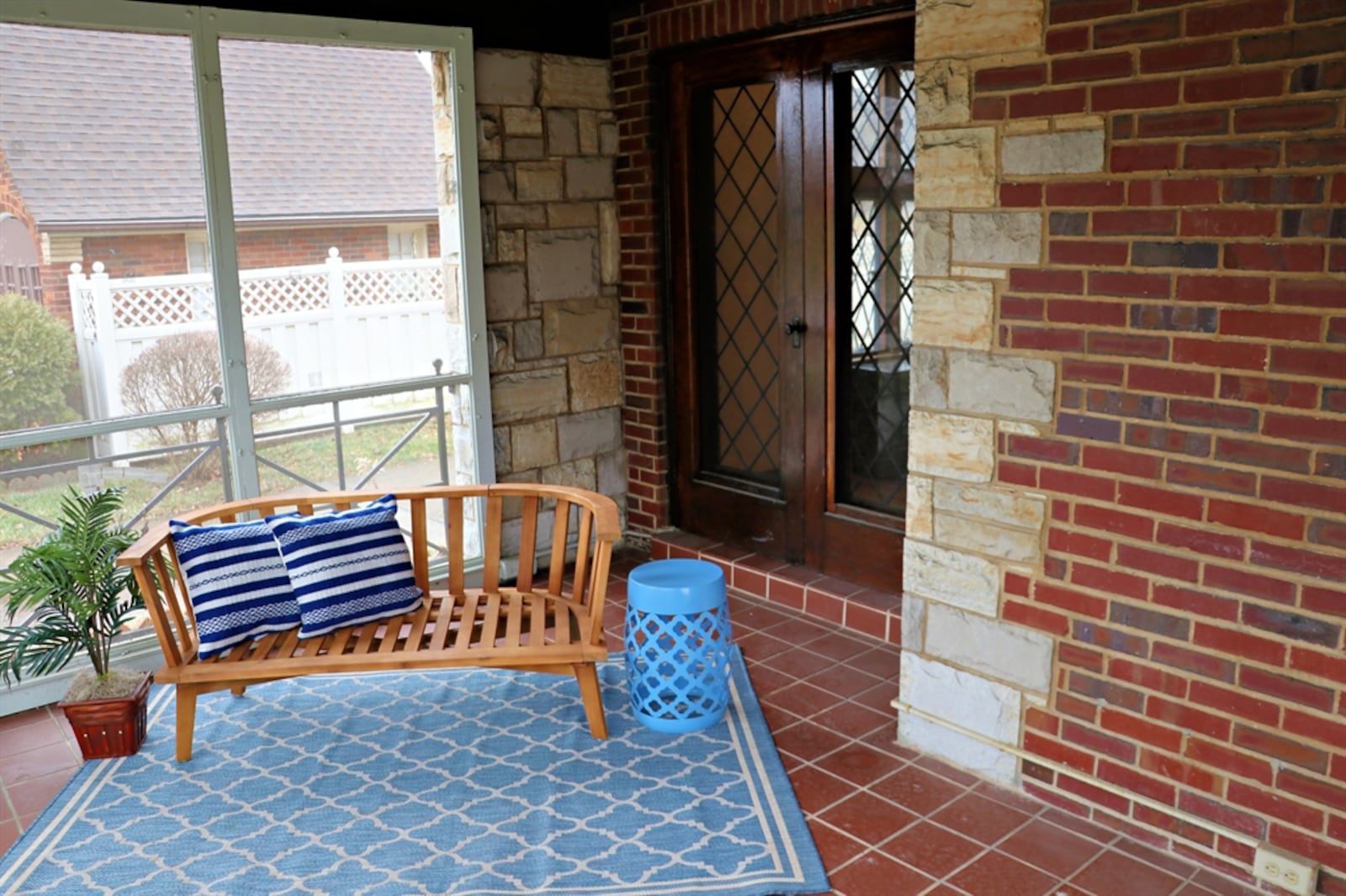 The property includes a screen-enclosed front porch with custom wrought-iron railing.