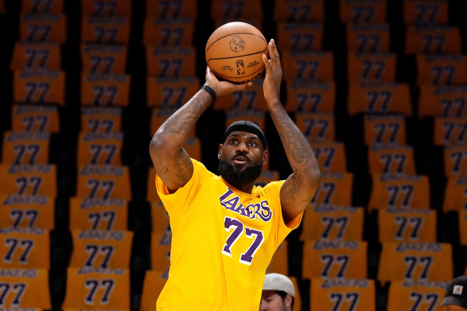 Los Angeles Lakers forward LeBron James warms up while wearing the number of guard Luka Doncic while additional T-shirts with Doncic's number are on seats prior to an NBA basketball game against the Utah Jazz, Monday, Feb. 10, 2025, in Los Angeles. (AP Photo/Mark J. Terrill)