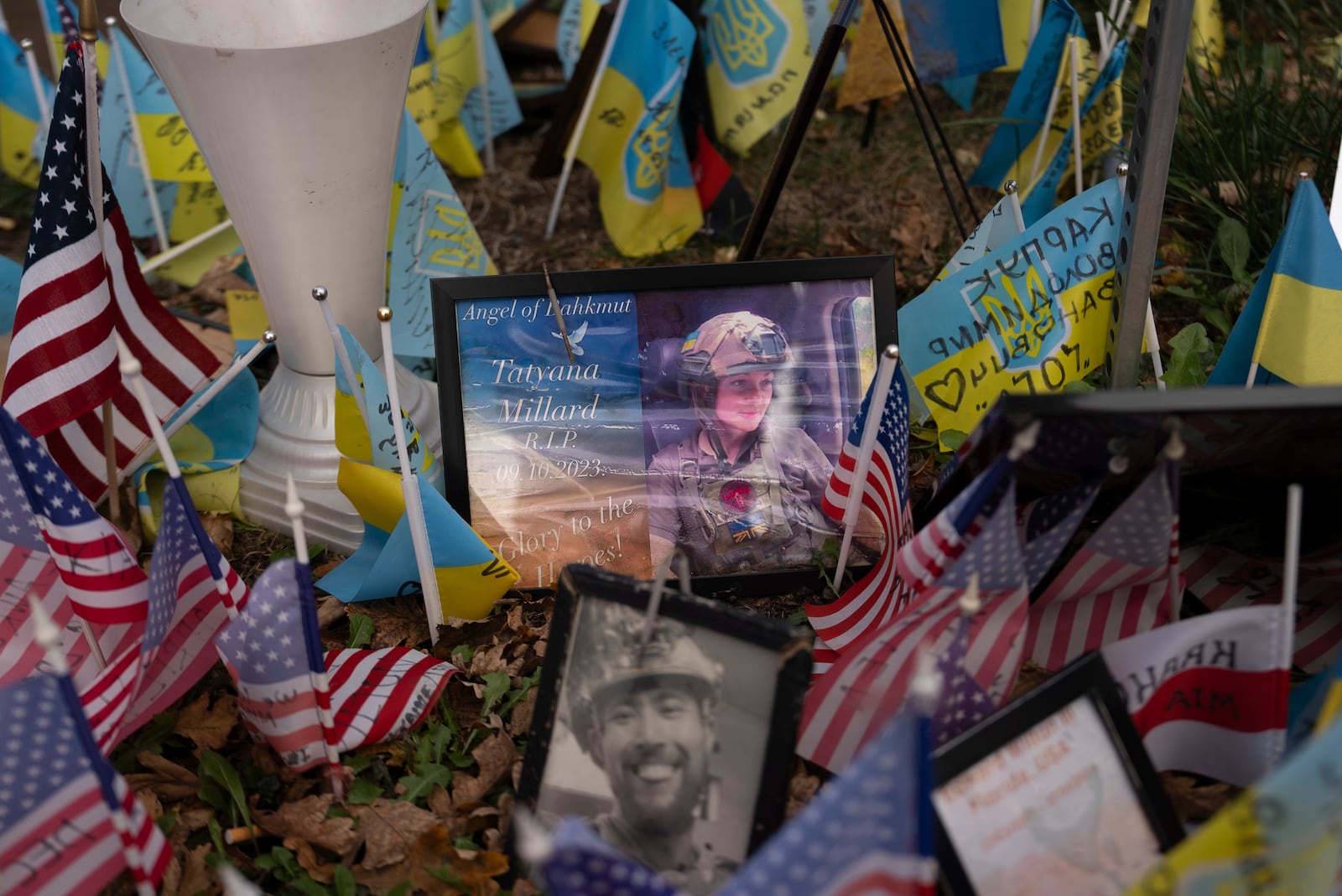 The memorial plate for Tatyana Millard, American volunteer, is seen among Ukrainian and American flags placed in honour of fallen servicemen in Independence Square in central Kyiv, Ukraine, Tuesday, Nov. 5, 2024. (AP Photo/Alex Babenko)