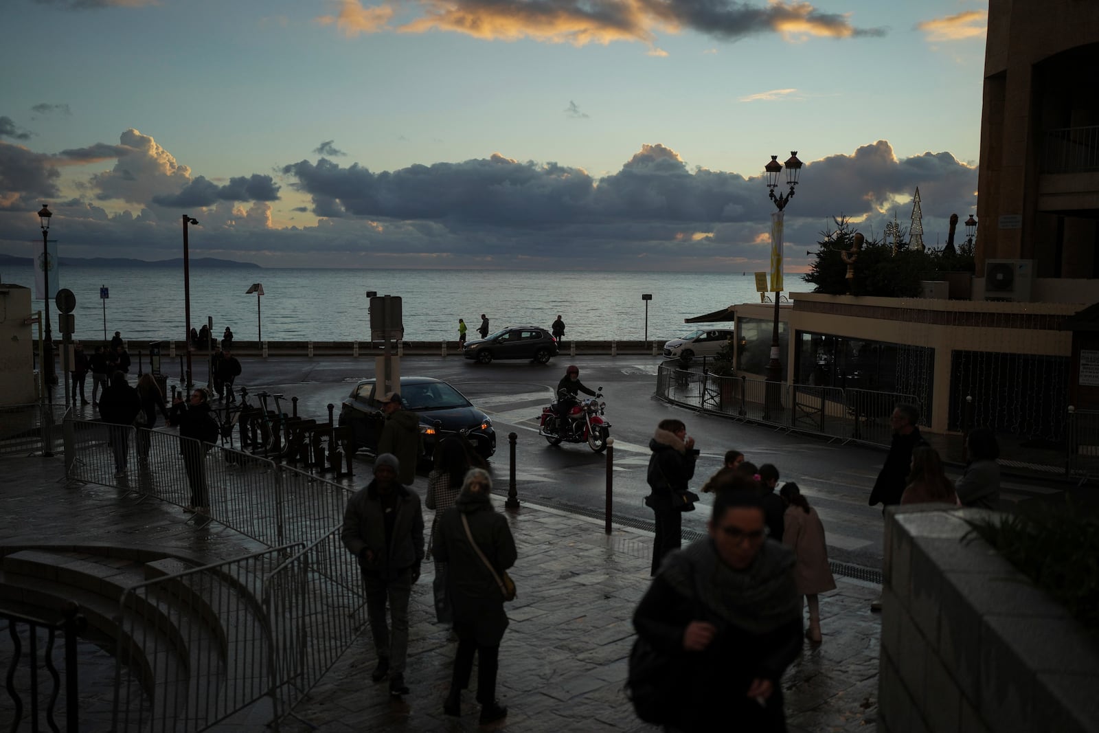 People walk near the seafront of Ajaccio prior to Pope Francis' visit, in the southern French island of Corsica, Saturday, Dec. 14, 2024. (AP Photo/Thibault Camus)