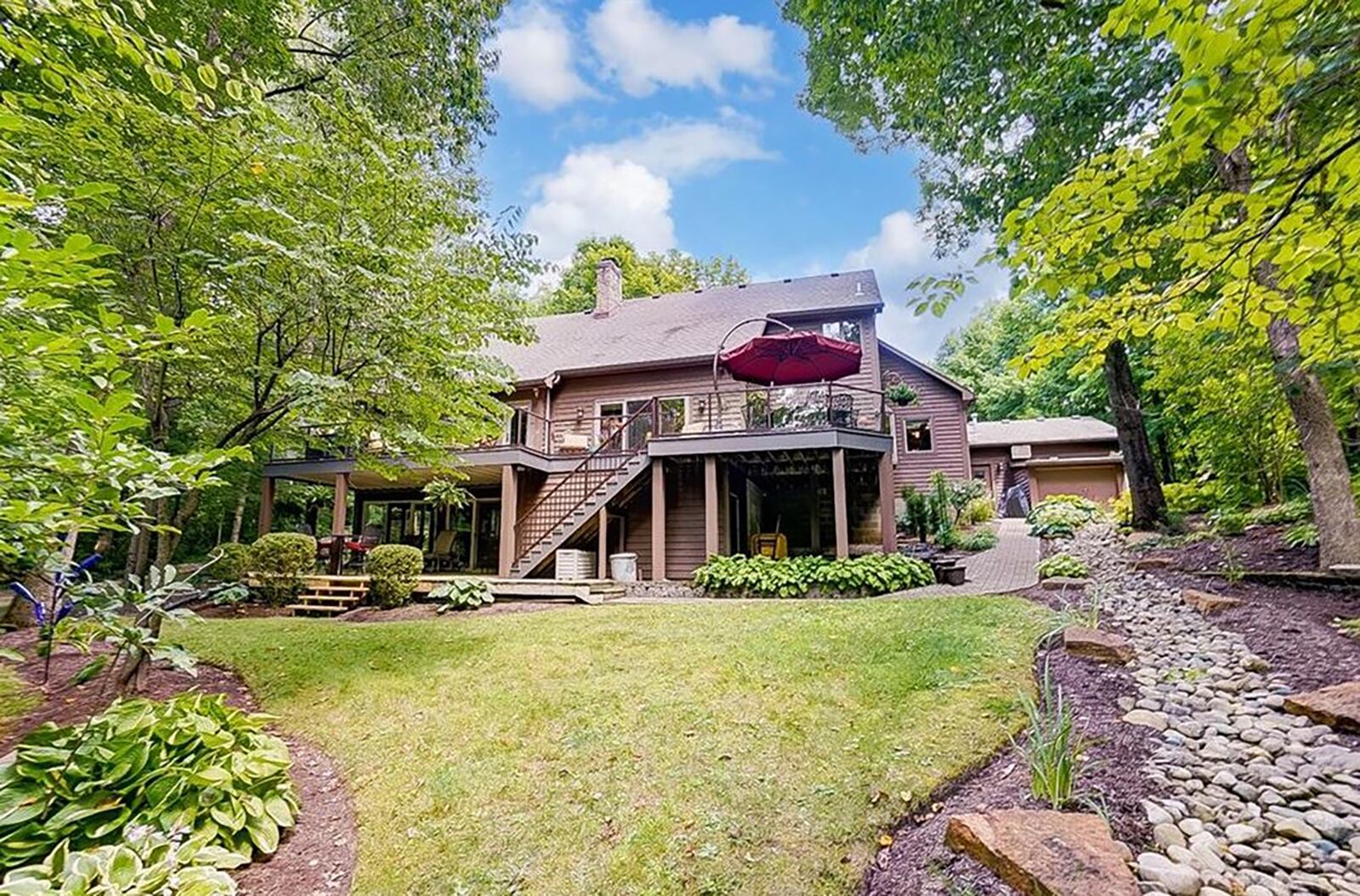 The rear of the home has multilevel decks, including a covered deck off the finished basement and an upper deck that spans the entirety of the rear of the home. The back yard has a firepit and stone creek bed with trickling water feature.