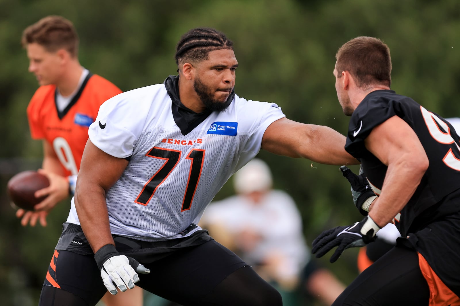 Cincinnati Bengals' La'el Collins, left, blocks Sam Hubbard during a drill at NFL football practice in Cincinnati, Tuesday, June 7, 2022. (AP Photo/Aaron Doster)