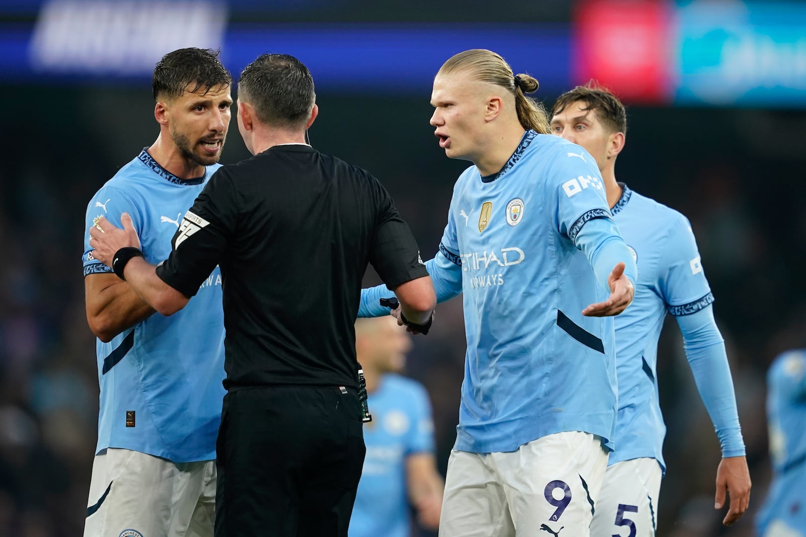 Manchester City's Erling Haaland, right, and Ruben Dias remonstrate with referee Michael Oliver during the English Premier League soccer match between Manchester City and Arsenal at the Etihad stadium in Manchester, England, Sunday, Sept. 22, 2024. (AP Photo/Dave Thompson)