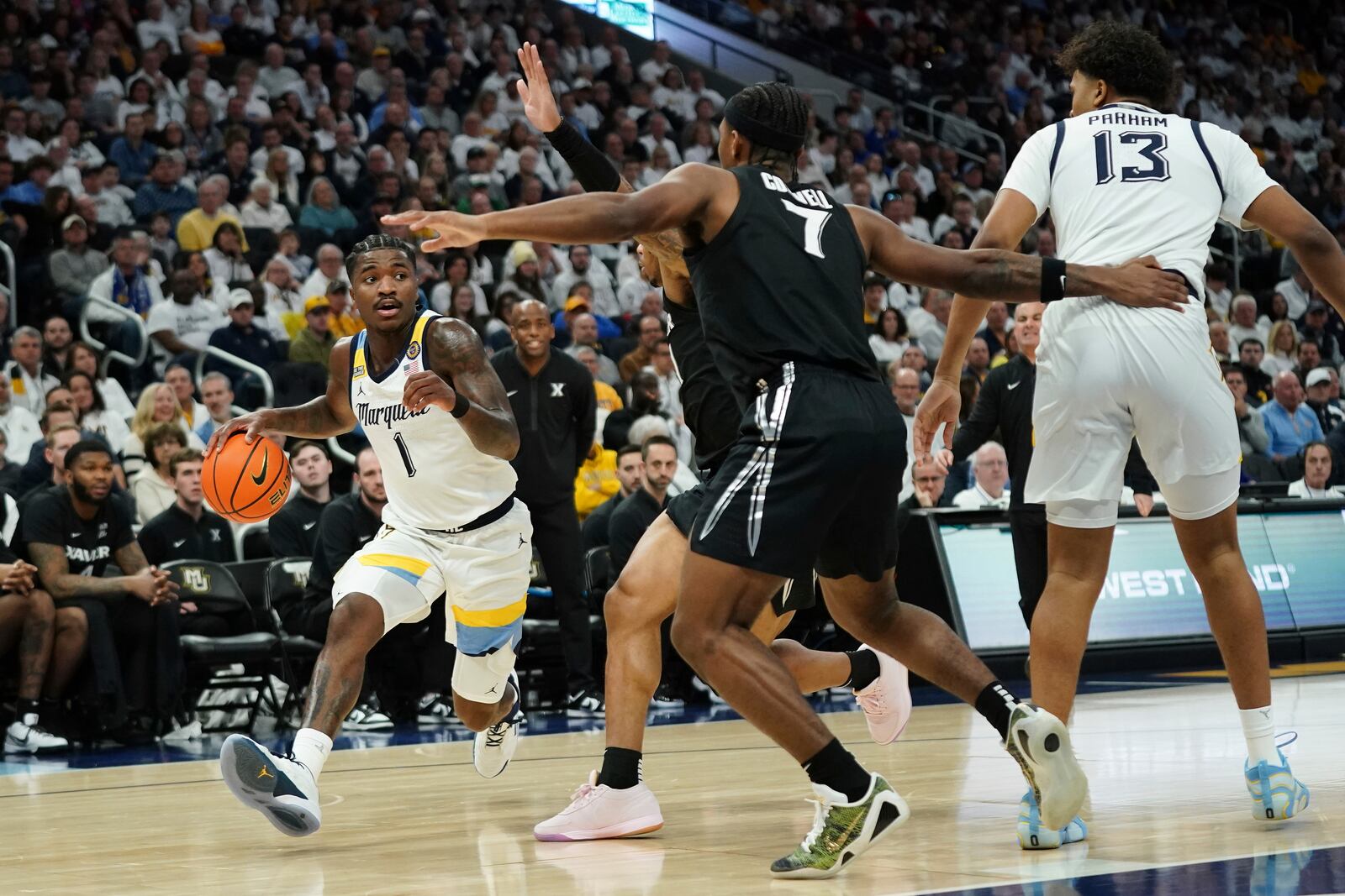 Marquette's Kam Jones (1) drives to the basket against multiple Xavier defenders during the first half of an NCAA college basketball game Saturday, Jan. 18, 2025, in Milwaukee. (AP Photo/Aaron Gash)