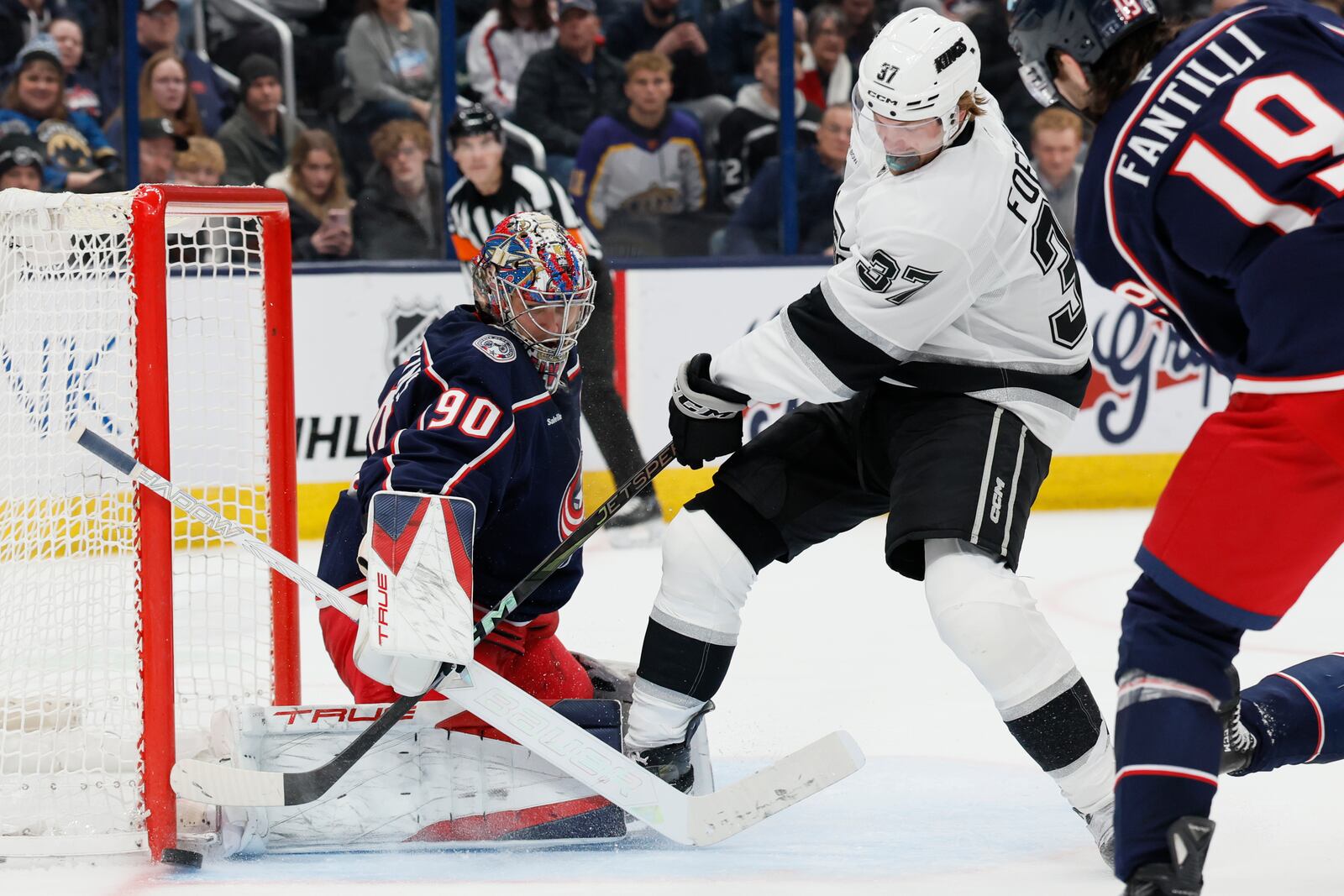 Columbus Blue Jackets' Elvis Merzlikins, left, makes a save against Los Angeles Kings' Warren Foegele (37) during the third period of an NHL hockey game Saturday, Jan. 25, 2025, in Columbus, Ohio. (AP Photo/Jay LaPrete)