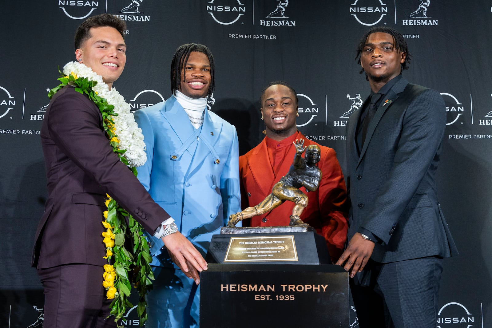 Heisman Trophy finalists, from left, Oregon's Dillon Gabriel, Colorado's Travis Hunter, Boise State's Ashton Jeanty and Miami's Cam Ward pose with the trophy during a college football press conference, Saturday, Dec. 14, 2024, in New York. (AP Photo/Corey Sipkin)