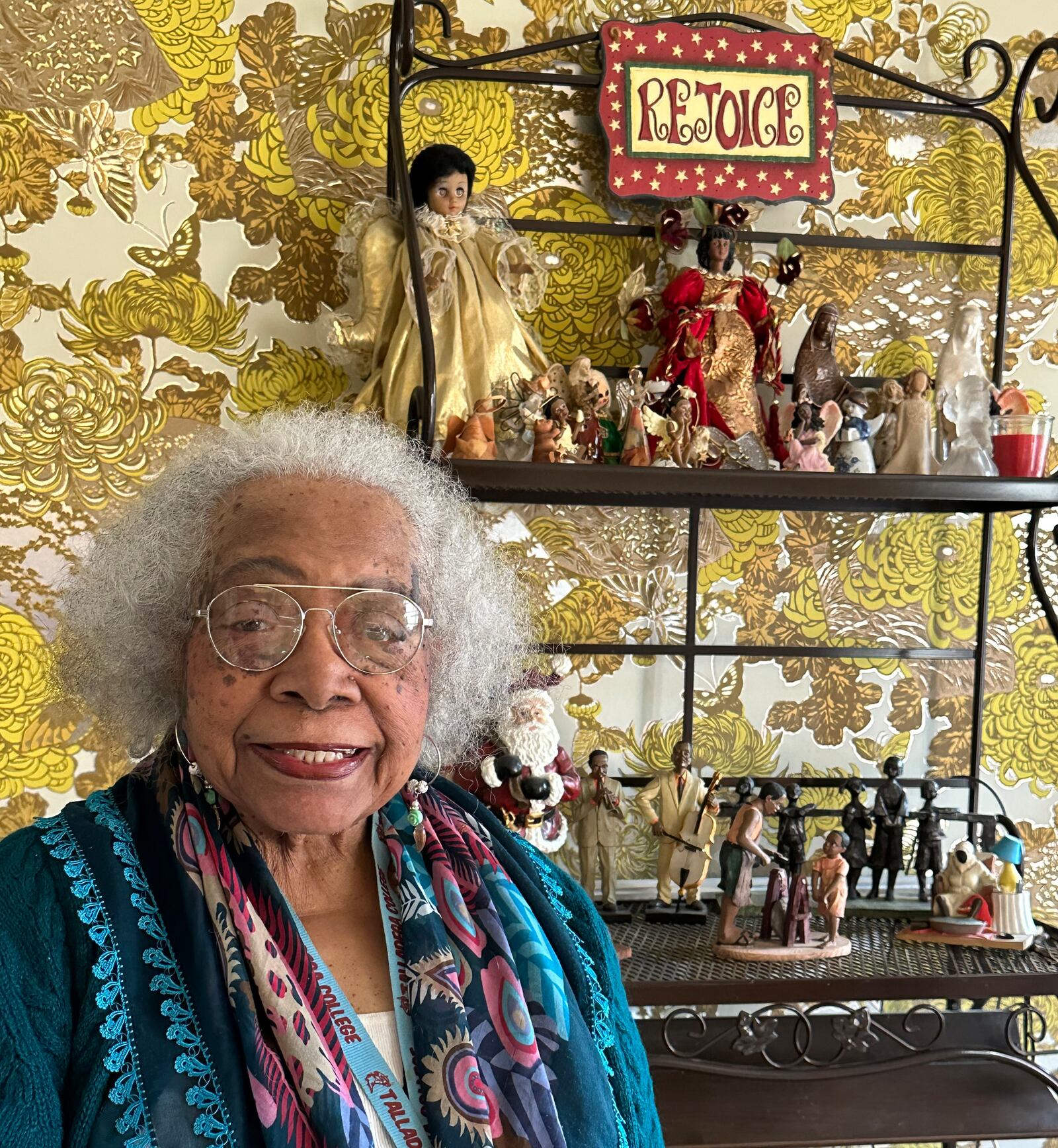 Terry Ogletree sits by her knick-knack shelves, covered with Black figurines. 