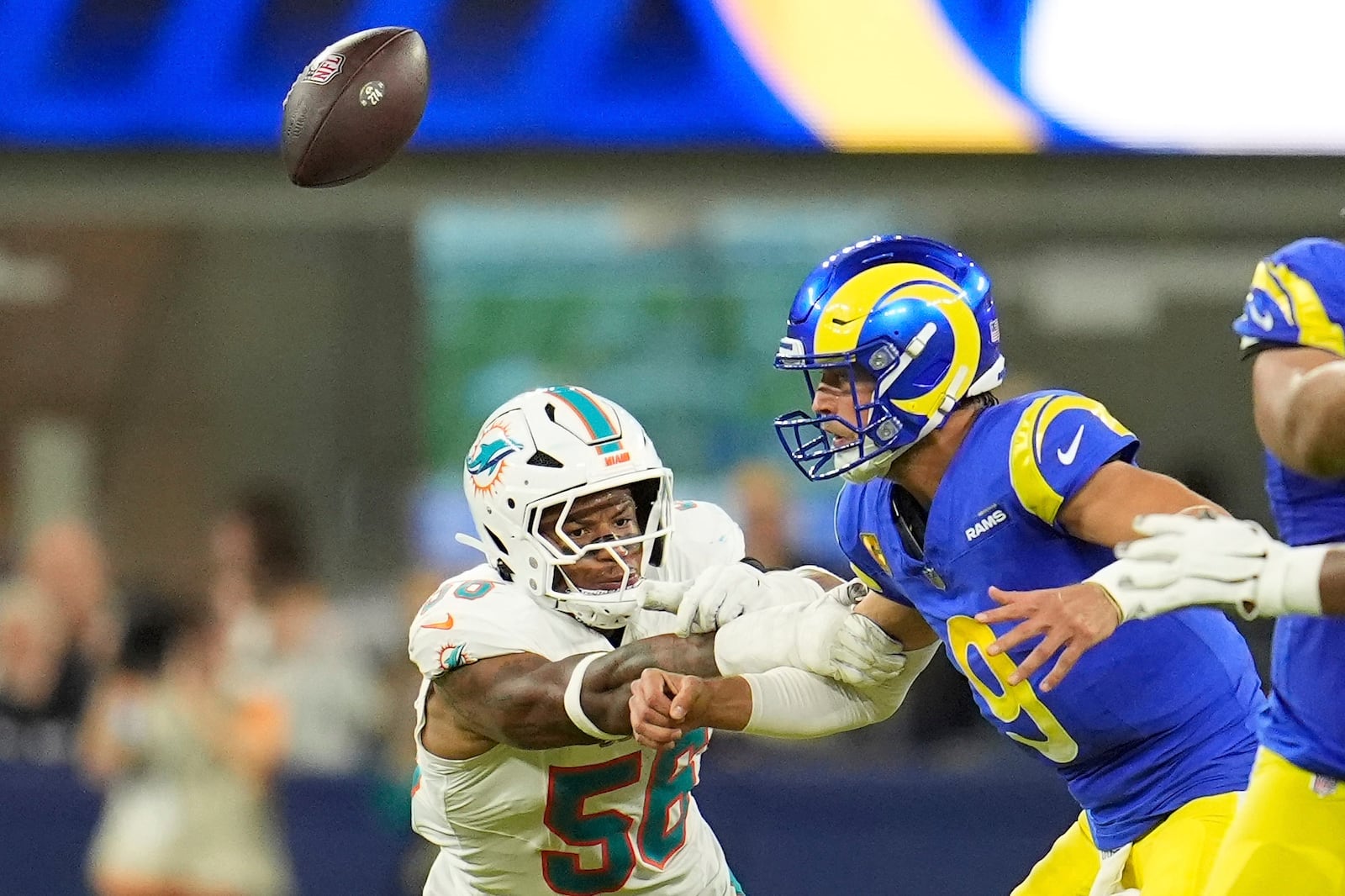 Miami Dolphins linebacker Quinton Bell, left, causes Los Angeles Rams quarterback Matthew Stafford to fumble the ball during the first half of an NFL football game, Monday, Nov. 11, 2024, in Inglewood, Calif. The ball was recovered by Stafford. (AP Photo/Marcio Jose Sanchez)