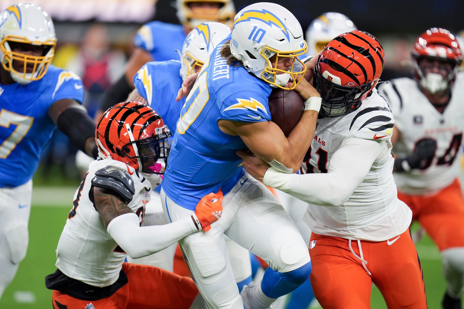 Los Angeles Chargers quarterback Justin Herbert (10) is tackled by Cincinnati Bengals defensive end Trey Hendrickson, right, during the first half of an NFL football game Sunday, Nov. 17, 2024, in Inglewood, Calif. (AP Photo/Gregory Bull)