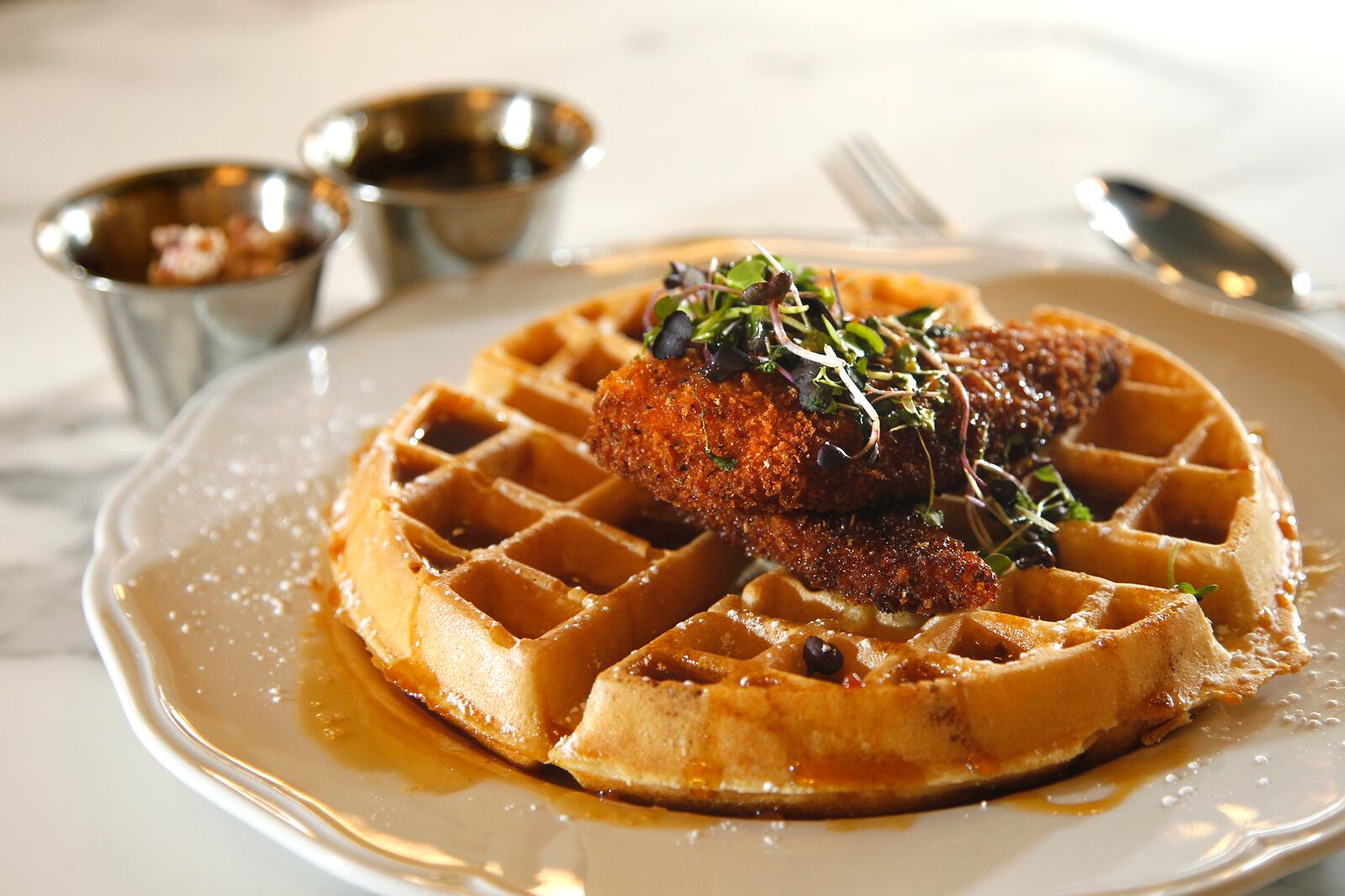 Chicken & Waffles make with Henny Penny's fried chicken and Belgian waffles sprinkled with powdered sugar, and served with blueberry butter and Cajun spiced syrup. It is one of the menu items for new expanded Culp's Cafe at Carillon Historical Park.  LISA POWELL / STAFF