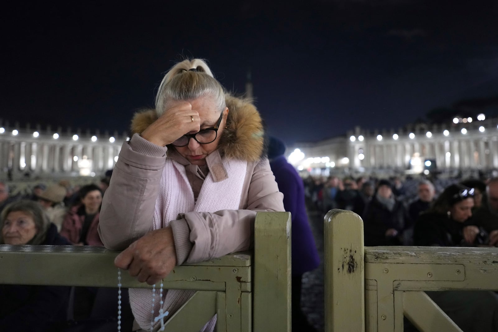 A woman attends a rosary prayer with Cardinal Victor Manuel Fernandez held for the health of Pope Francis in St Peter's Square at The Vatican, Friday, Feb. 28, 2025. (AP Photo/Kirsty Wigglesworth)