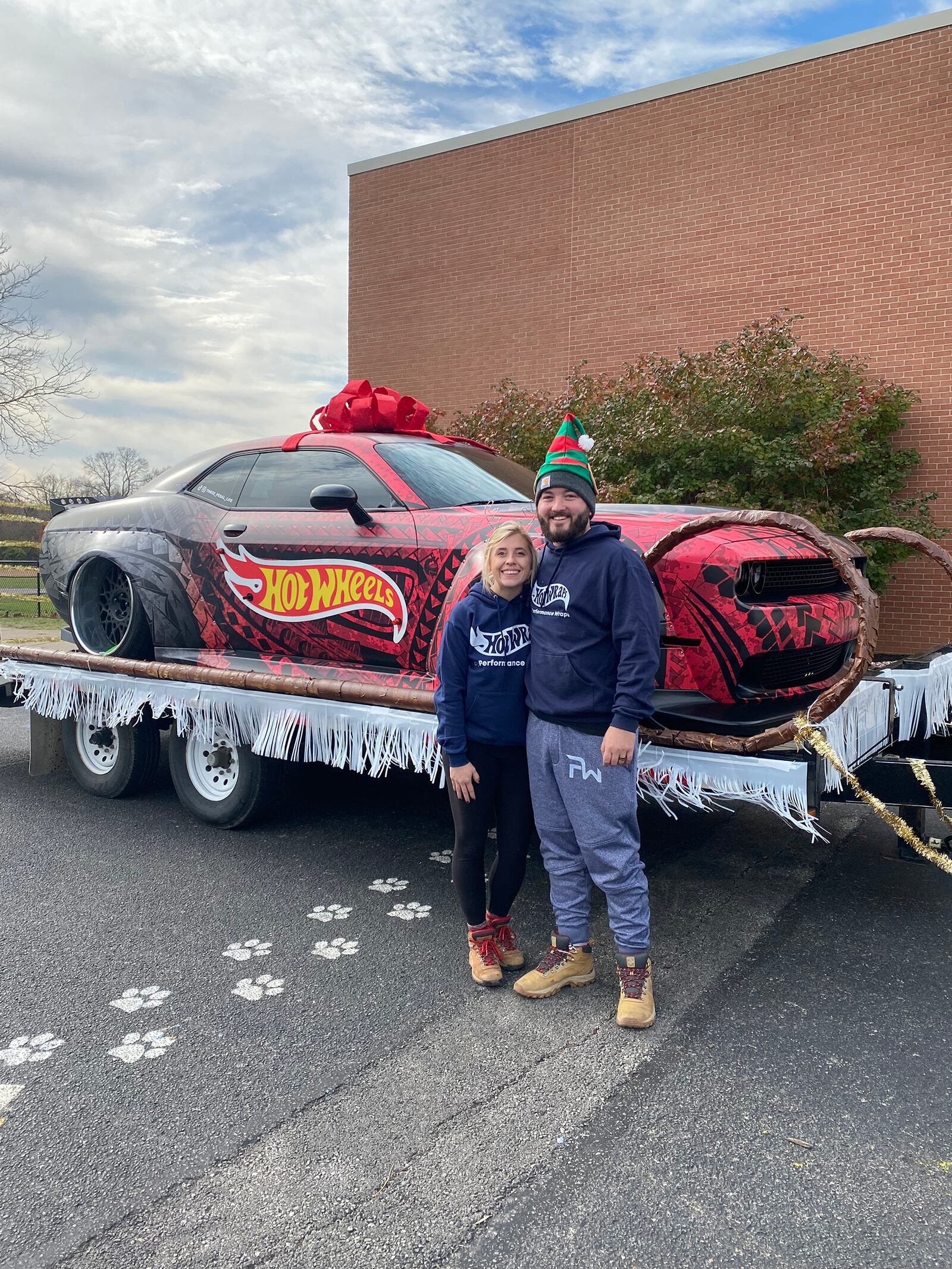 Andrew Banks (R) and his wife, Tanor, in front of a car their company, Performance Wraps, customized with a vinyl wrap.