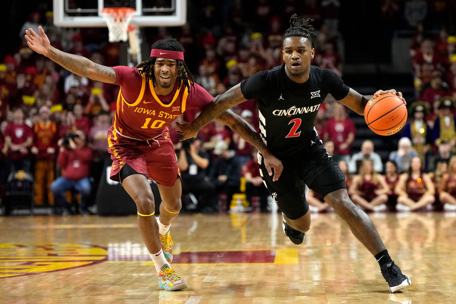 Cincinnati guard Jizzle James (2) drives to the basket past Iowa State guard Keshon Gilbert (10) during the first half of an NCAA college basketball game Saturday, Feb. 15, 2025, in Ames, Iowa. (AP Photo/Charlie Neibergall)