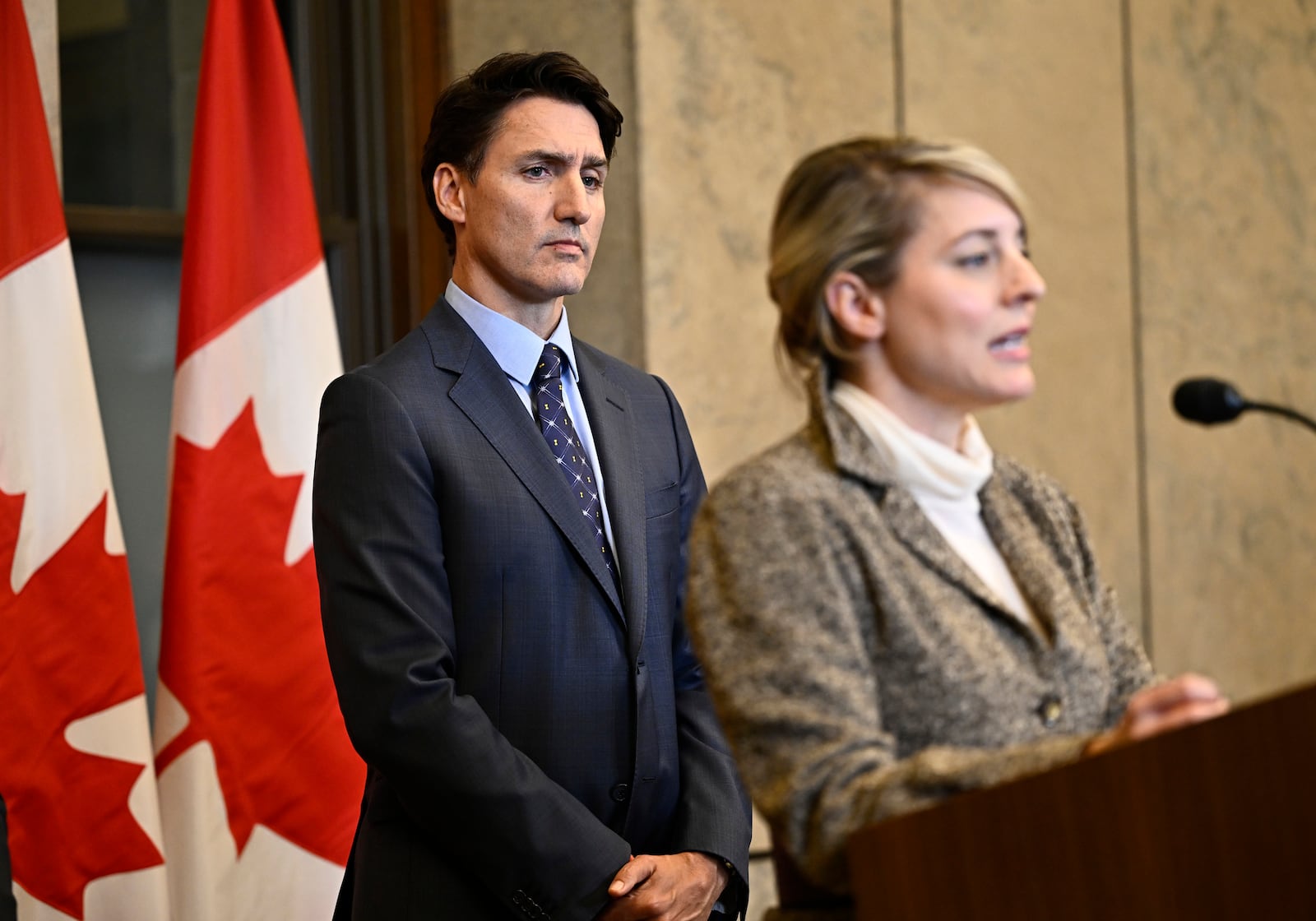 Prime Minister Justin Trudeau listens as Minister of Foreign Affairs Melanie Joly speaks at a news conference on the investigative efforts related to violent criminal activity occurring in Canada with connections to India, on Parliament Hill in Ottawa, on Monday, Oct. 14, 2024. (Justin Tang/The Canadian Press via AP)