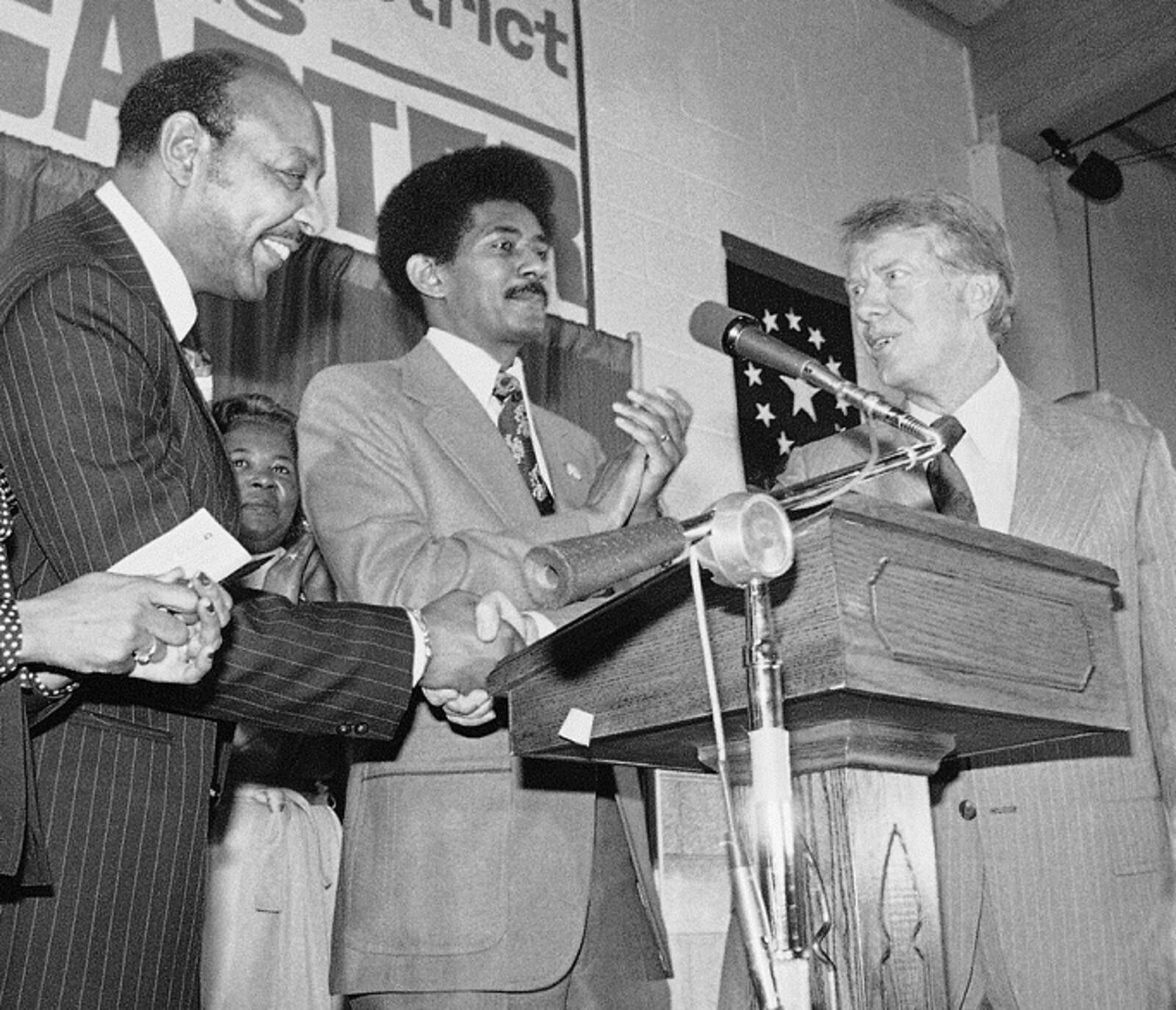 Rep. Louis Stokes (left), D-Ohio, and Democratic Presidential candidate Jimmy Carter exchange handshakes and quips while Rev. Otis Moss Jr. looked on during Carter's meeting with religious leaderships, Saturday, Oct. 9, 1976 in Cleveland, Ohio. After Stokes mentioned the site of the church in which they met, 88th and Quincy, Carter responded that he could become the first President in history to know it well, "89th and Quincy." (AP Photo)