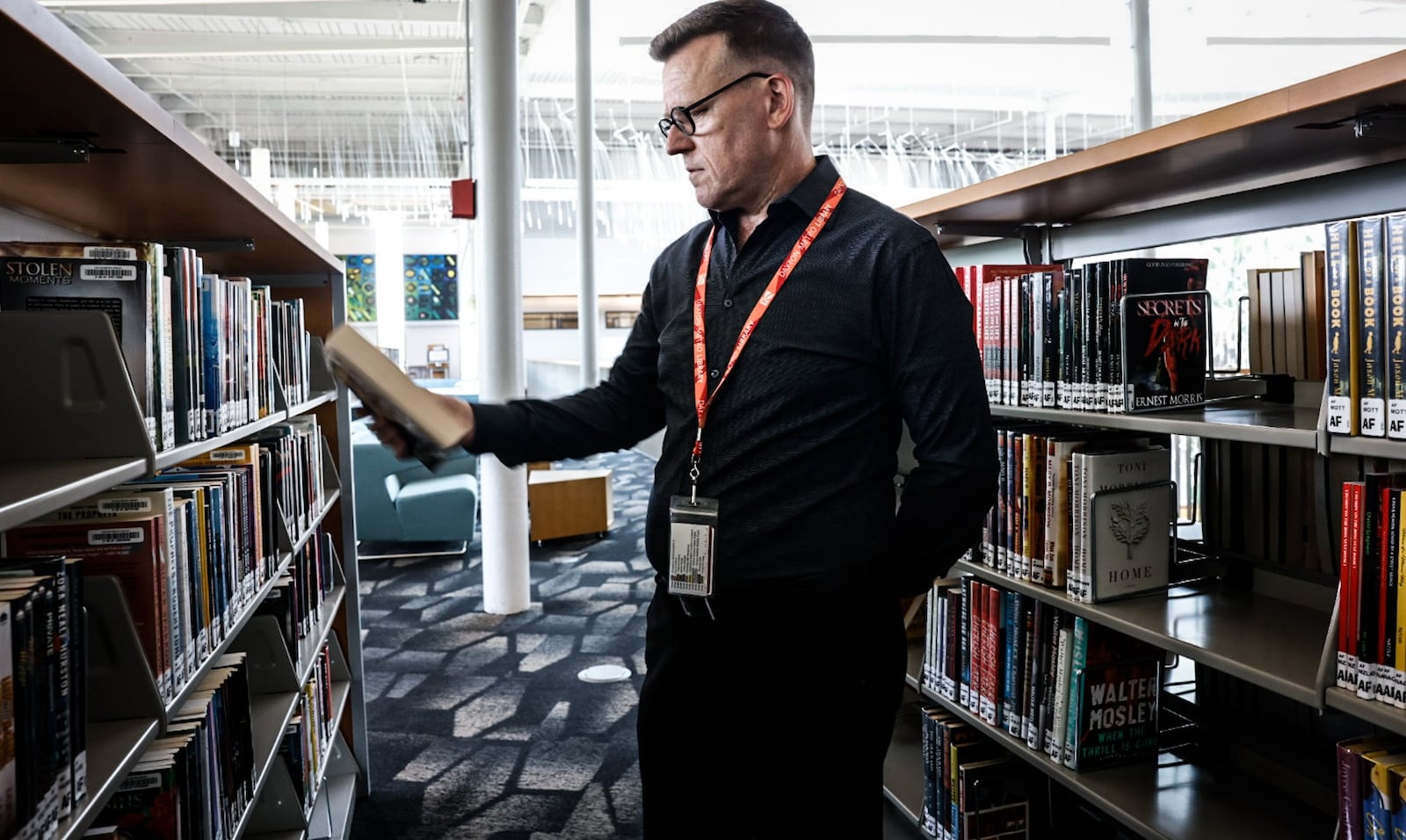 Dayton Metro Library executive director Jefferey Trzeciak looks through the stacks Wednesday June 21, 2023. The Dayton Metro Library has been declared a book sanctuary which means the library collects and protects endangered books. JIM NOELKER/STAFF