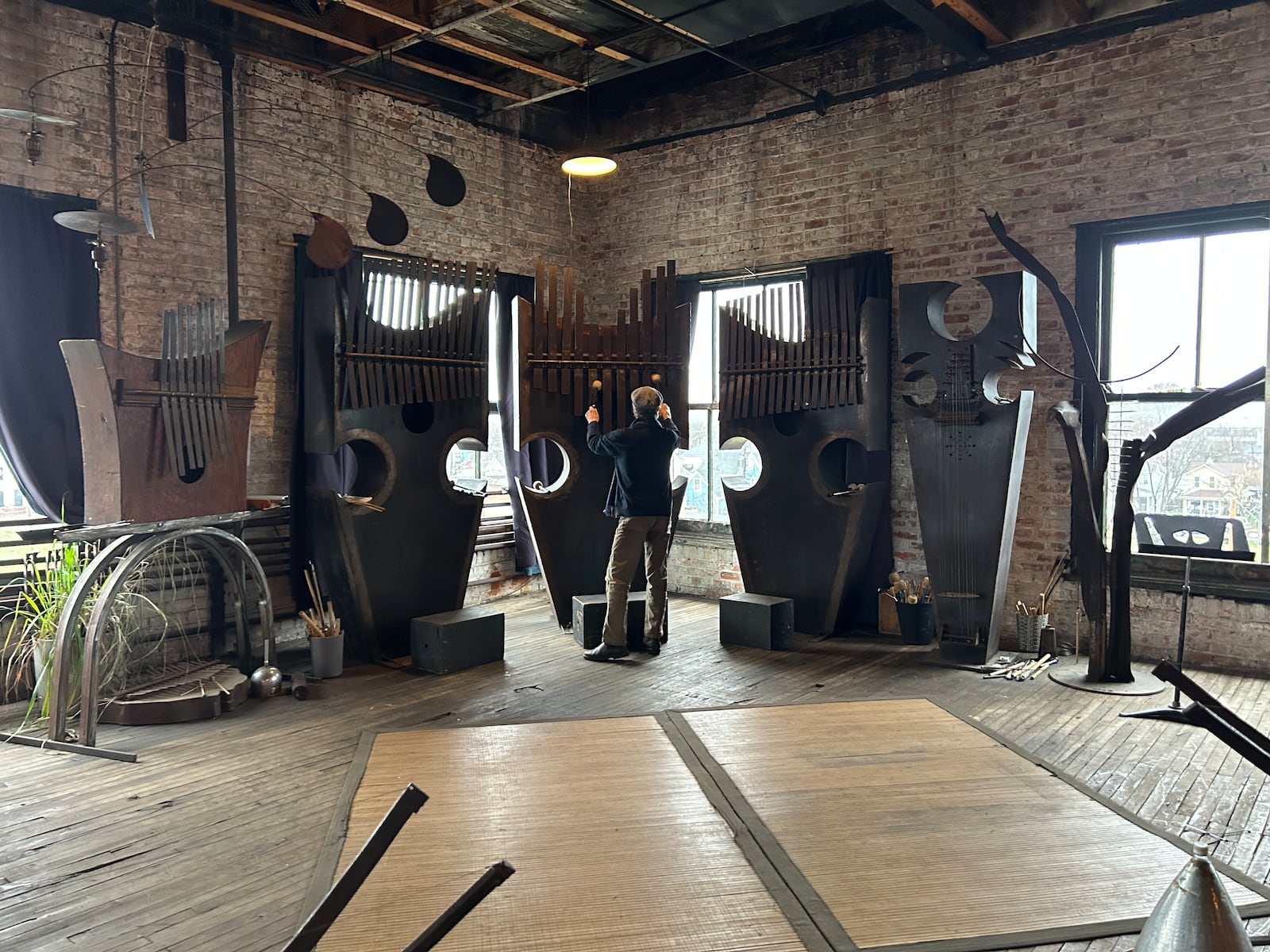 Michael Bashaw playing one of his Sound Sculptures in his East Dayton studio.