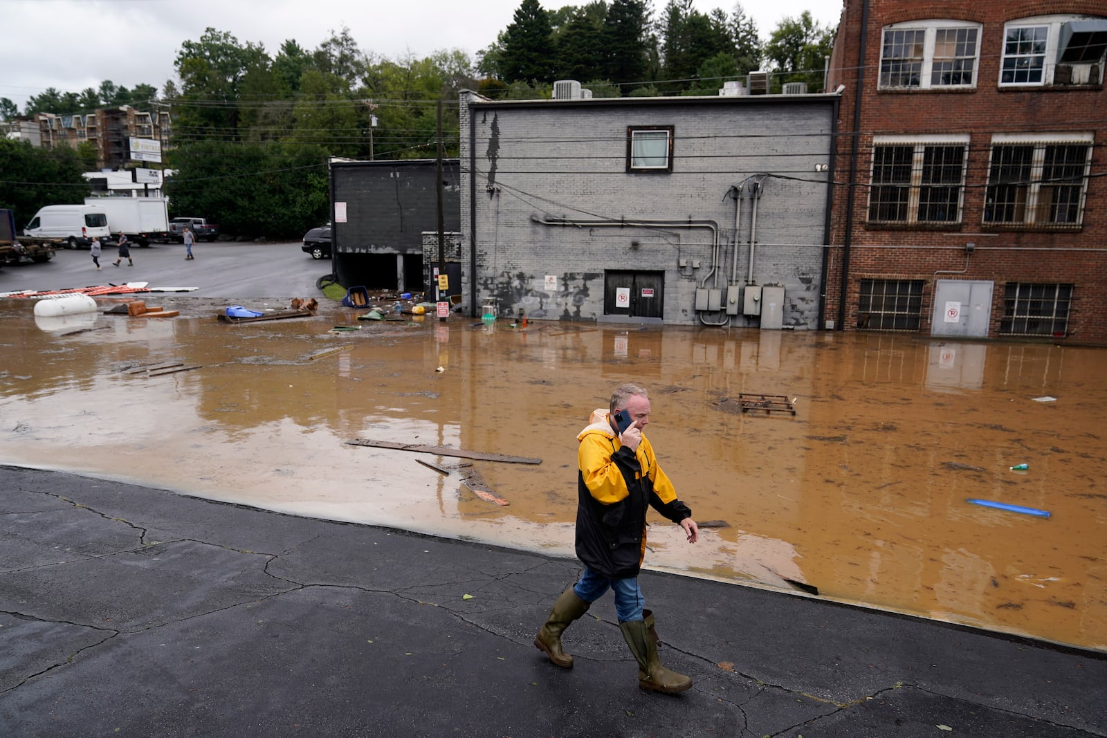 FILE - A man walks near a flooded area near the Swannanoa river, effects from Hurricane Helene , Friday, Sept. 27, 2024, in Asheville, N.C. (AP Photo/Erik Verduzco, File)