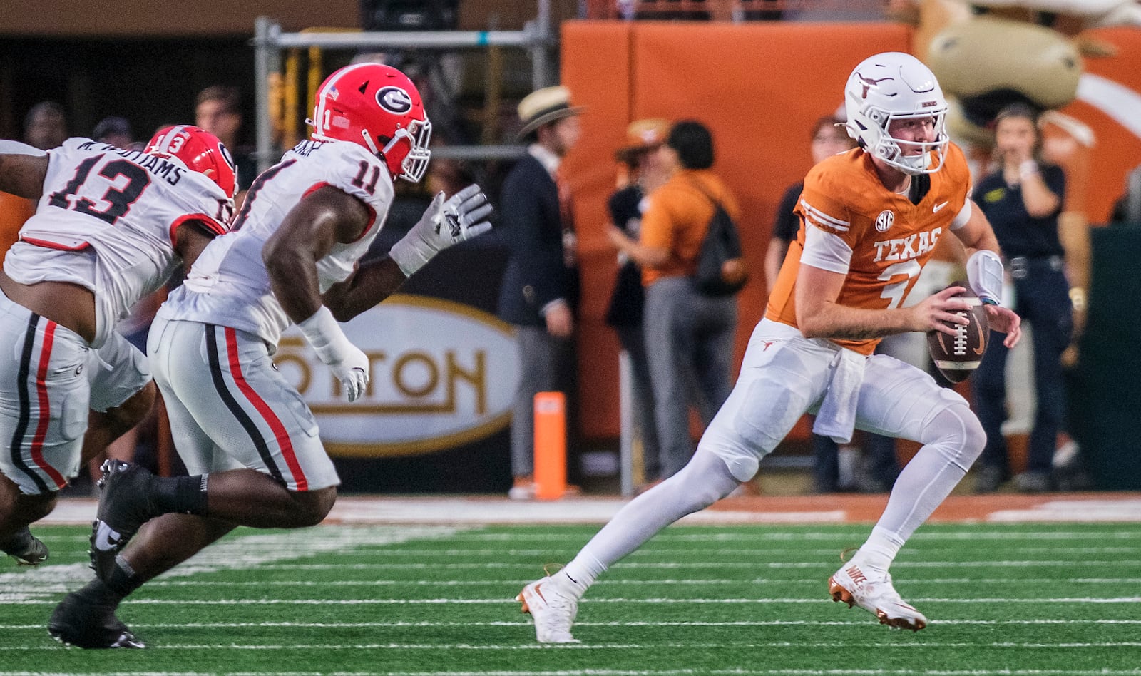 Texas quarterback Quinn Ewers (3) is chased out of the pocket by Georgia defensive lineman Mykel Williams (13) and linebacker Jalon Walker (11) during the first half of an NCAA college football game in Austin, Texas, Saturday, Oct. 19, 2024. (AP Photo/Rodolfo Gonzalez)