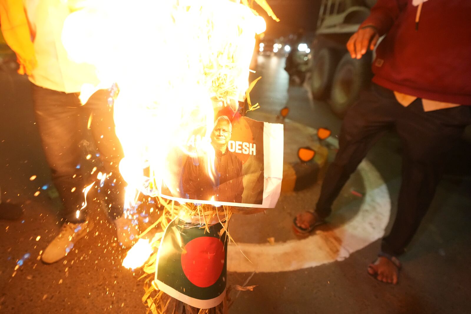 Activists of Bajarang dal, a Hindu rights group, burn an effigy of Bangladesh's interim leader Muhammad Yunus and a symbolic flag of Bangladesh, during a protest against the alleged attacks on Hindus in Bangladesh, in Ahmedabad, India, Wednesday, Dec. 11, 2024. (AP Photo/Ajit Solanki)