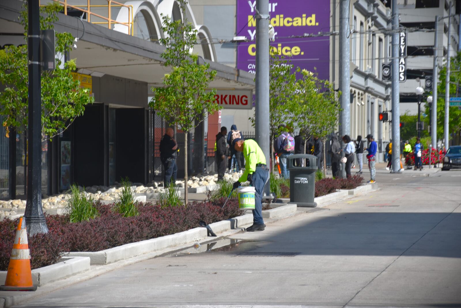 A downtown Dayton ambassador picks up trash in flower beds along South Jefferson Street near the Greater Dayton RTA bus hub downtown. The city paid to install new landscaping that is designed to try to prevent loitering and other problems. CORNELIUS FROLIK / STAFF