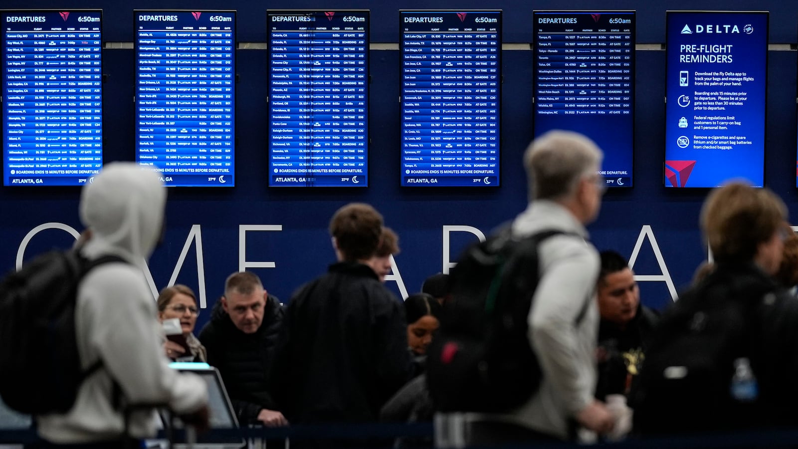 Travelers move through Hartsfield-Jackson Atlanta International Airport, Friday, Dec. 20, 2024, in Atlanta. (AP Photo/Mike Stewart)