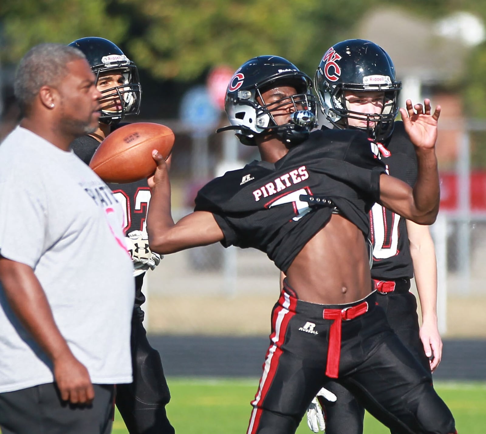 West Carrollton High School football QB Kamaury Cleveland delivers as head coach Dion Black (left) watches during practice on Wednesday, Oct. 9, 2019. MARC PENDLETON / STAFF