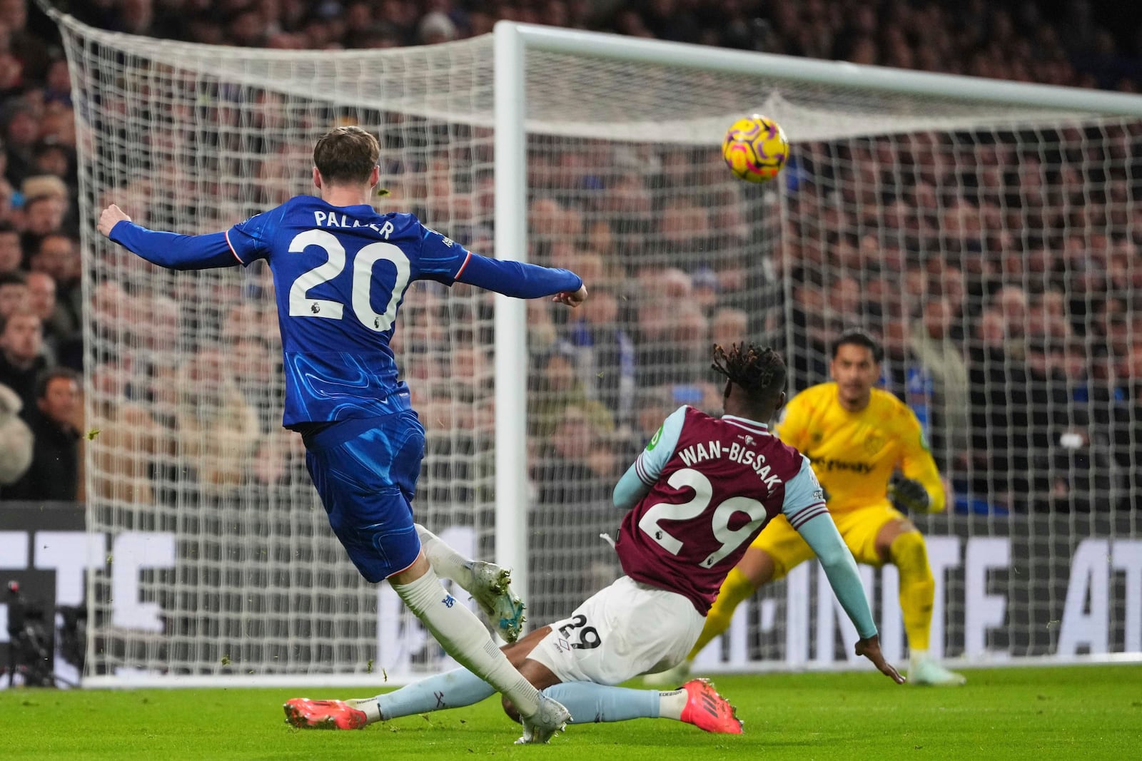 West Ham's Aaron Wan-Bissaka scores an own goal besides Chelsea's Cole Palmer during the English Premier League soccer match between Chelsea and West Ham United at Stamford Bridge stadium in London, Monday, Feb. 3, 2025. (AP Photo/Kirsty Wigglesworth)