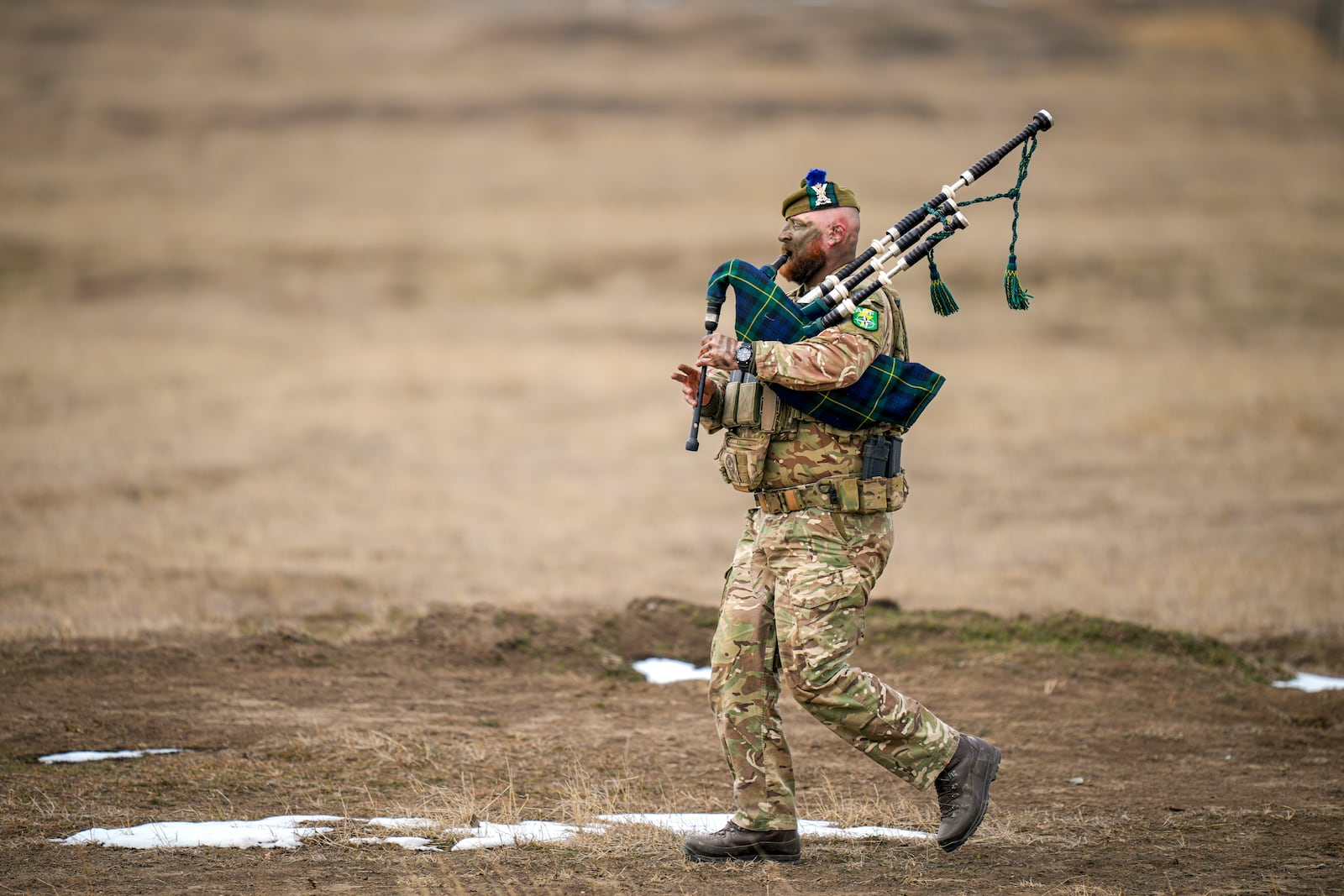 A Scottish piper attached to British troops plays the pipe at the end of the Steadfast Dart 2025 exercise, involving some 10,000 troops in three different countries from nine nations and represent the largest NATO operation planned this year, at a training range in Smardan, eastern Romania, Wednesday, Feb. 19, 2025. (AP Photo/Vadim Ghirda)