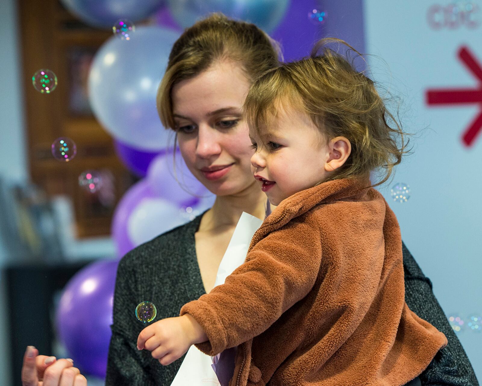 A child and her mother catch bubbles as they depart the Wright Care Child Development Center on April 29. U.S. AIR FORCE PHOTO/JAIMA FOGG