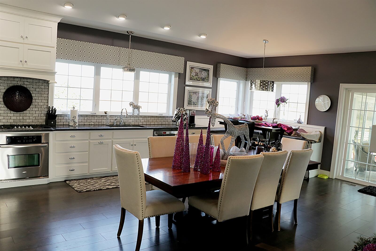 White cabinetry fills two walls of the kitchen area with a single-sink below three large windows. There is a pantry closet and stainless-steel appliances, including a gas range. CONTRIBUTED PHOTO BY KATHY TYLER