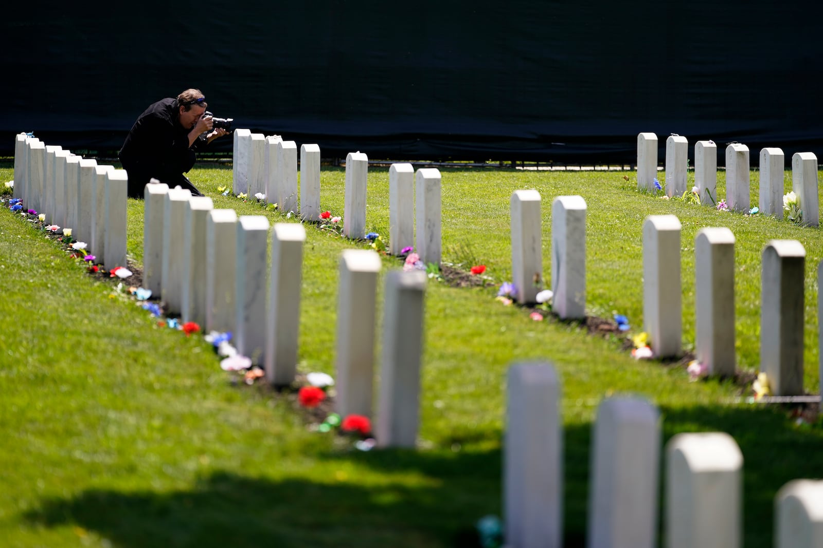 FILE - A member of the media photographs headstones at the cemetery of the U.S. Army's Carlisle Barracks, June 10, 2022, in Carlisle, Pa. (AP Photo/Matt Slocum, File)