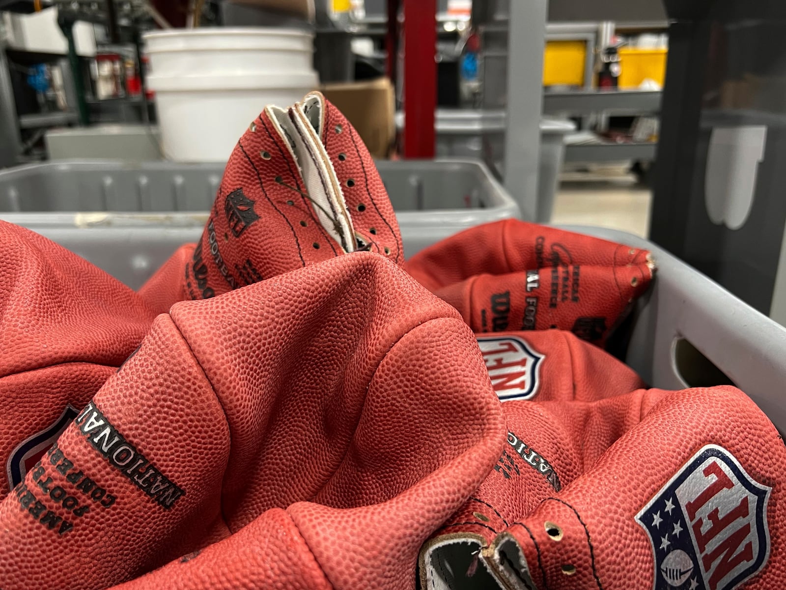 A bin of official balls for the NFL Super Bowl football game wait to be finished inside the Wilson Sporting Goods football factory, Monday, January 27, 2025, in Ada, Ohio. (AP Photo/Patrick Aftoora-Orsagos)