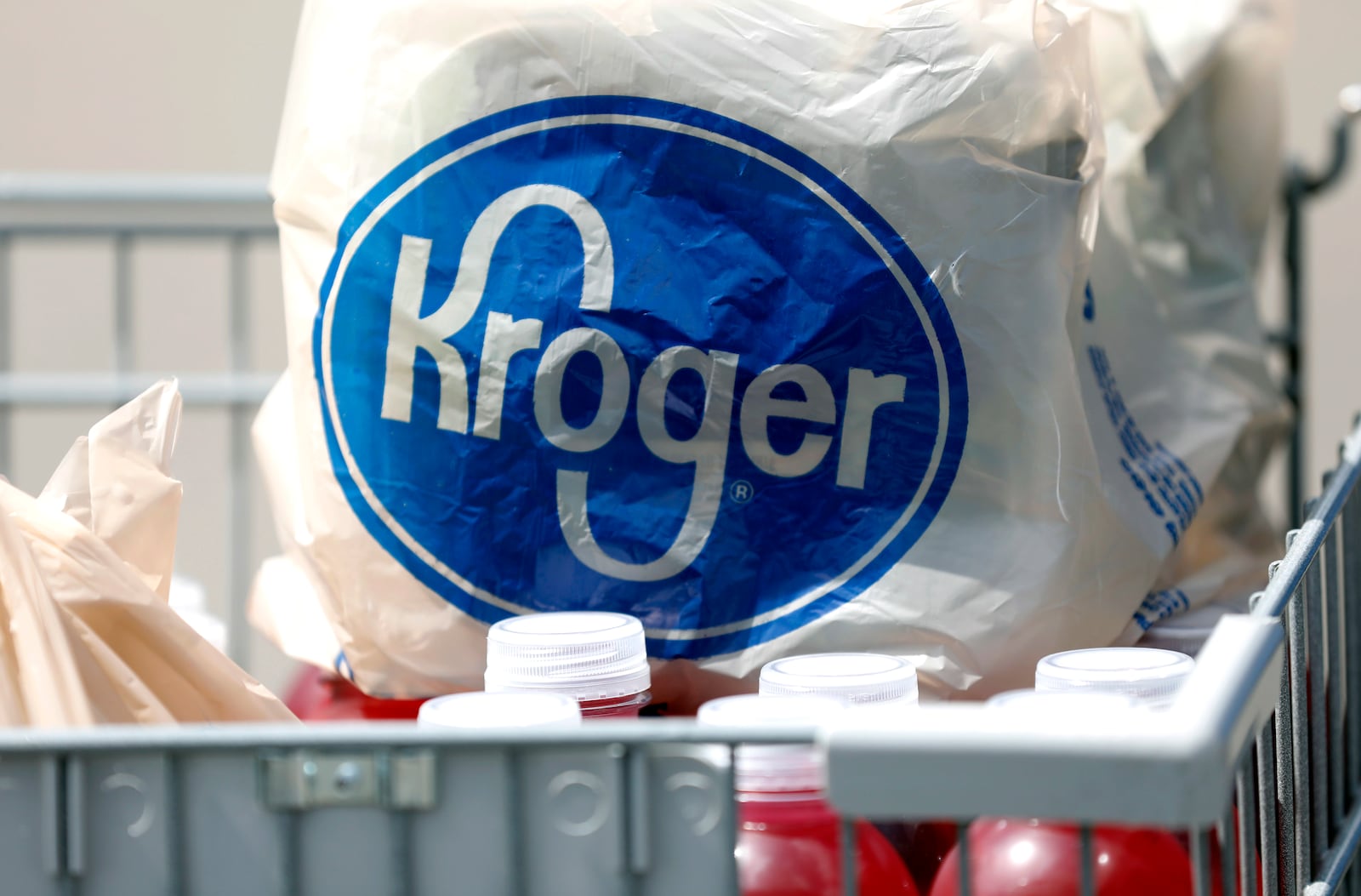 FILE- In this June 15, 2017, file photo, bagged purchases from a Kroger grocery store sit in a shopping cart in Flowood, Miss. Kroger Co. will close two supermarkets in Southern California in response to a local ordinance requiring extra pay for certain grocery employees working during the coronavirus pandemic. The decision announced by the company Monday, Feb. 1, 2021, follows a unanimous vote last month by the Long Beach City Council mandating a 120-day increase of $4 an hour for employees of supermarkets with at least 300 employees nationwide and more than 15 in Long Beach. (AP Photo/Rogelio V. Solis, File)