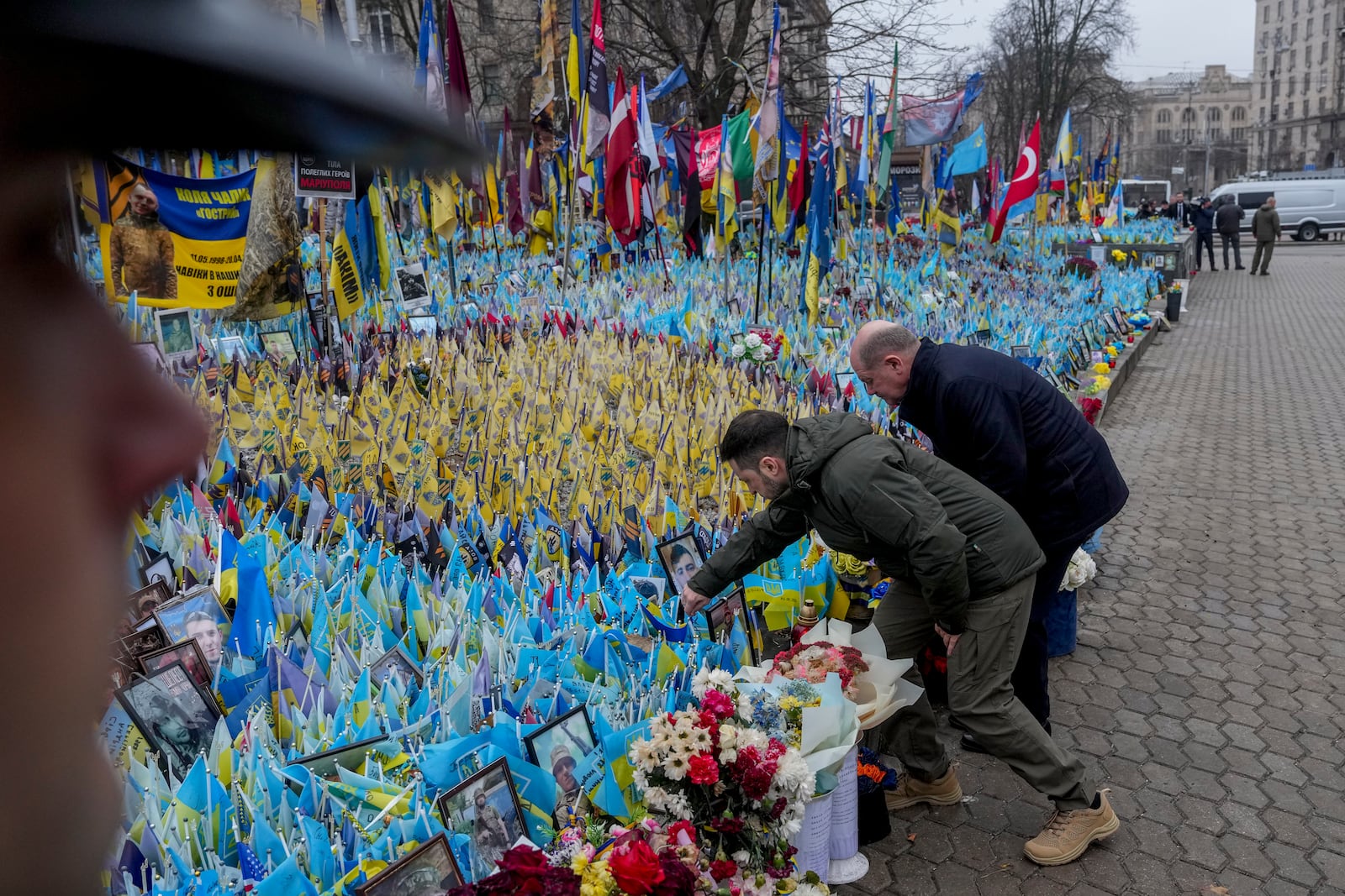 Ukraine's President Volodymyr Zelenskyy, left, and German Chancellor Olaf Scholz attend a ceremony of honoring fallen soldiers near the People's Memorial of National Memory in Kyiv, Ukraine, Monday, Dec.2, 2024. (AP Photo/Evgeniy Maloletka)