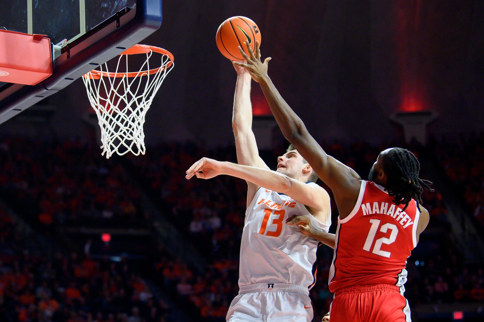 Ohio State's Evan Mahaffey (12) attempts to block a shot by Illinois' Tomislav Ivisic (13) during the first half of an NCAA college basketball game Sunday, Feb. 2, 2025, in Champaign, Ill. (AP Photo/Craig Pessman)