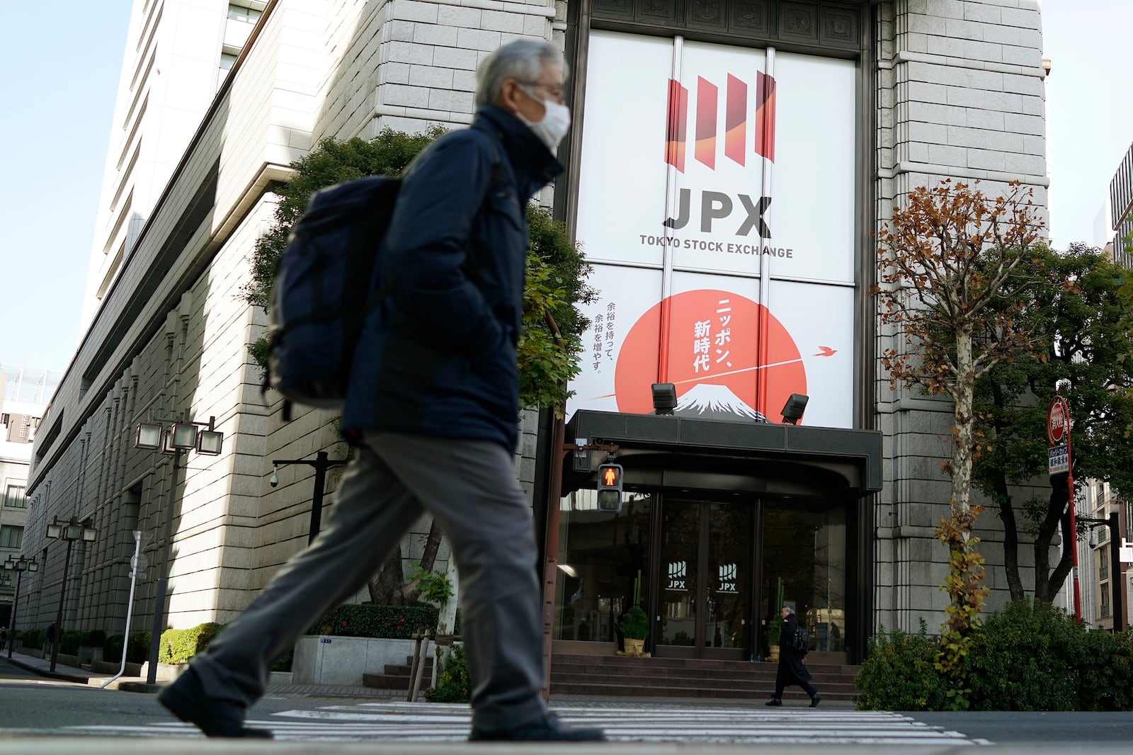 People walk in front of Tokyo Stock Exchange building Wednesday, Dec. 25, 2024, in Tokyo. (AP Photo/Eugene Hoshiko)