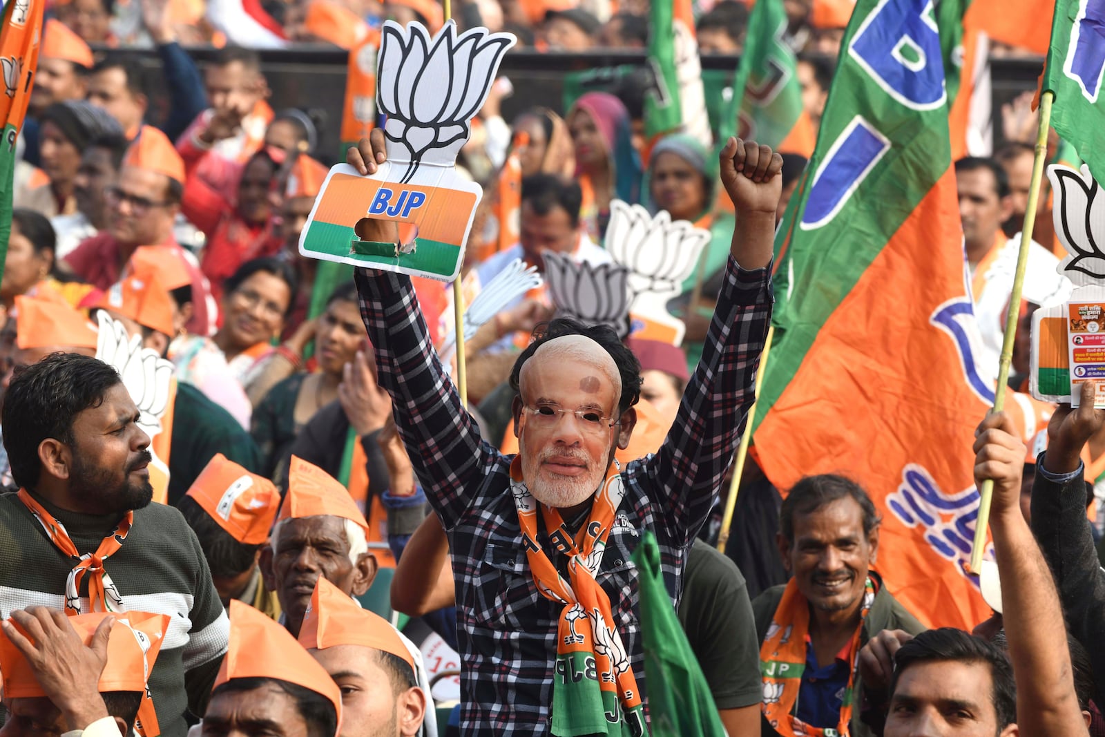 A supporter of Bharatiya Janata party, or BJP, wears a mask of Indian prime minister Narendra Modi and shouts slogans during Delhi state election campaign rally in New Delhi, India, Friday, Jan. 31, 2025. (AP Photo)