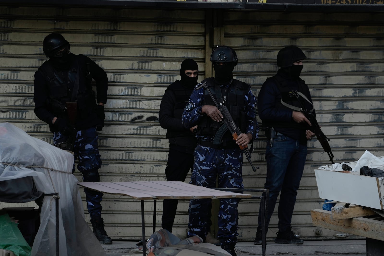 Officers from the Palestinian Authority clutch their guns as Palestinian security forces mount a major raid against militants in the Jenin refugee camp in the Israeli-occupied West Bank, Monday, Dec. 16, 2024. (AP Photo/Majdi Mohammed)