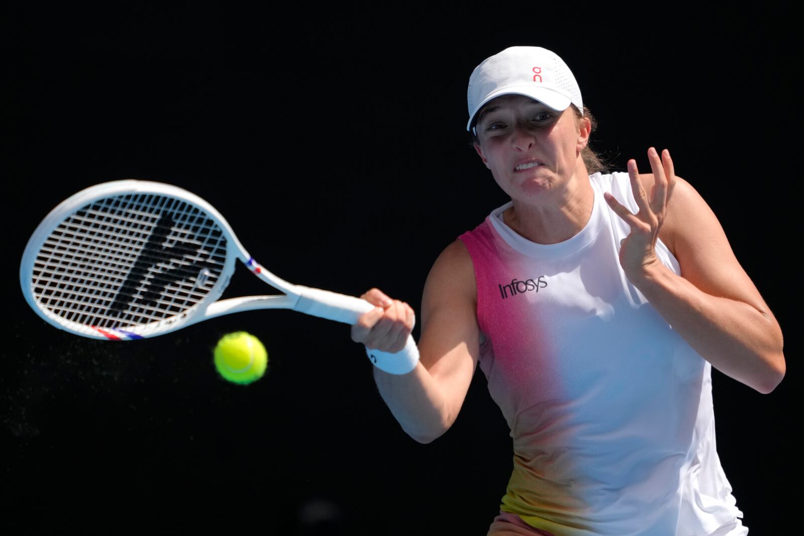 Iga Swiatek of Poland plays a forehand return to Katerina Siniakova of the Czech Republic during their first round match at the Australian Open tennis championship in Melbourne, Australia, Monday, Jan. 13, 2025. (AP Photo/Ng Han Guan)