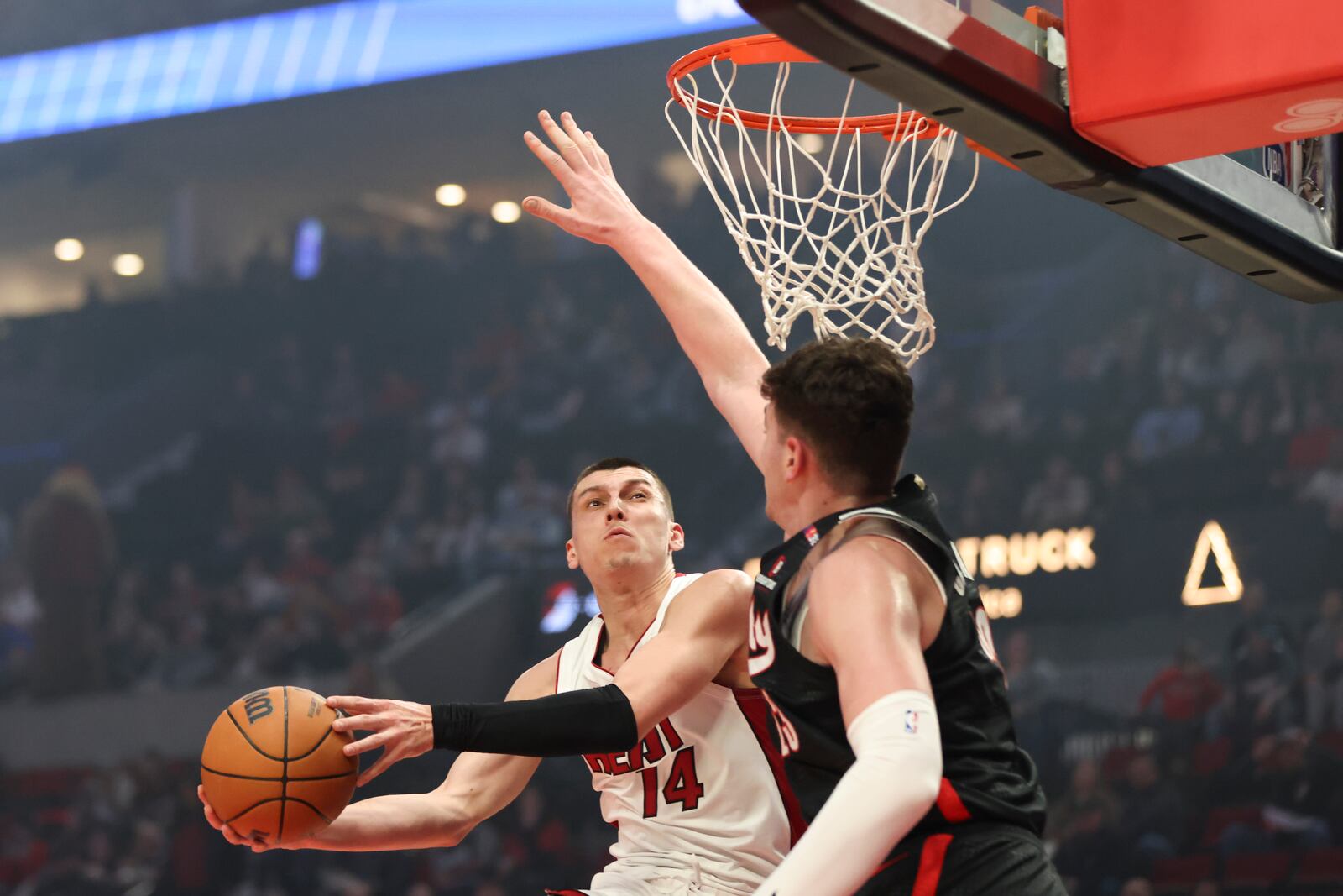 Miami Heat guard Tyler Herro (14) shoots past Portland Trail Blazers center Donovan Clingan (23) during the first half of an NBA basketball game Saturday, Jan. 11, 2025, in Portland, Ore. (AP Photo/Amanda Loman)