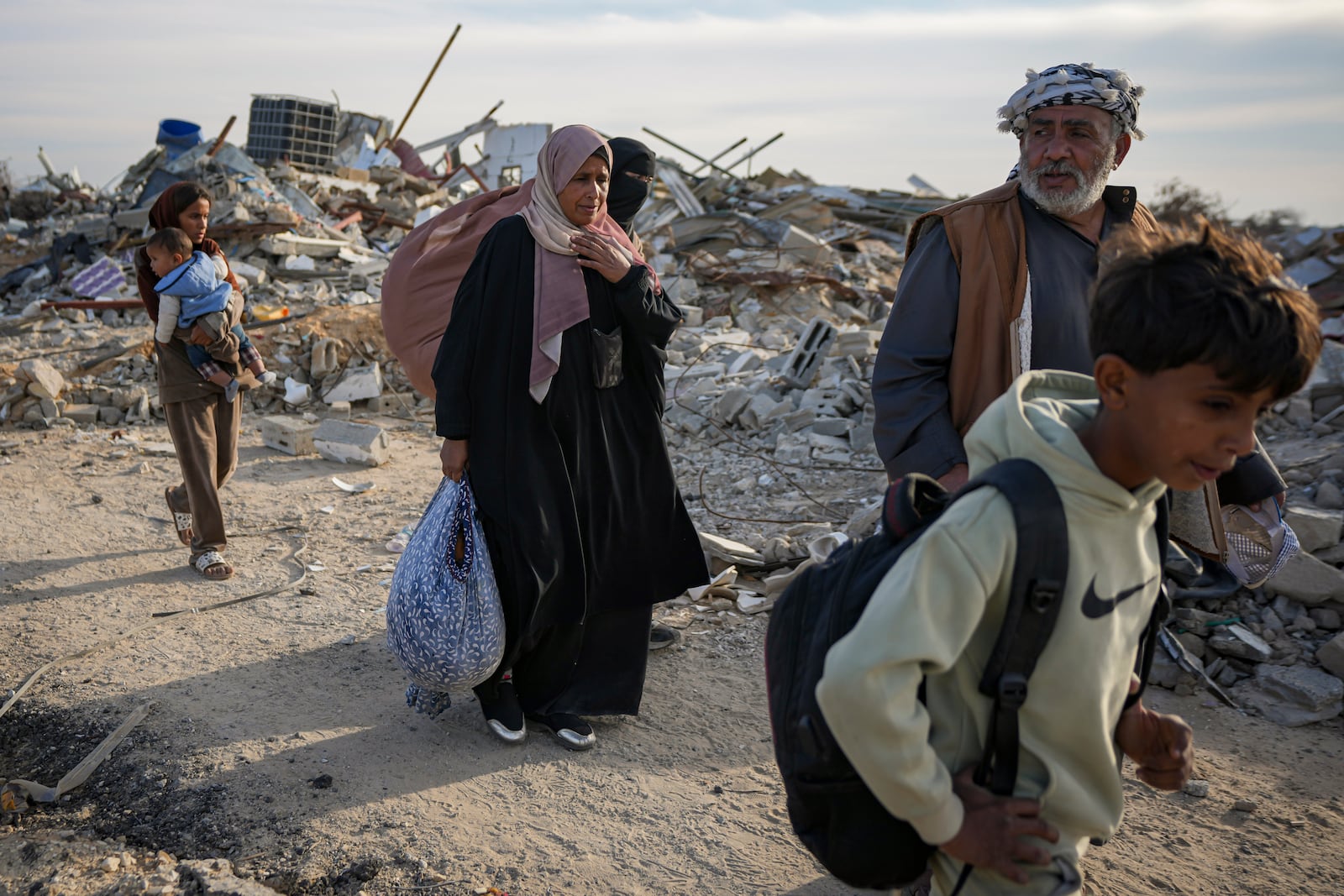 Members of the Abu Sheiban family return to their home in Rafah, days after the ceasefire deal between Israel and Hamas, southern Gaza Strip, Tuesday, Jan. 21, 2025. (AP Photo/Abdel Kareem Hana)