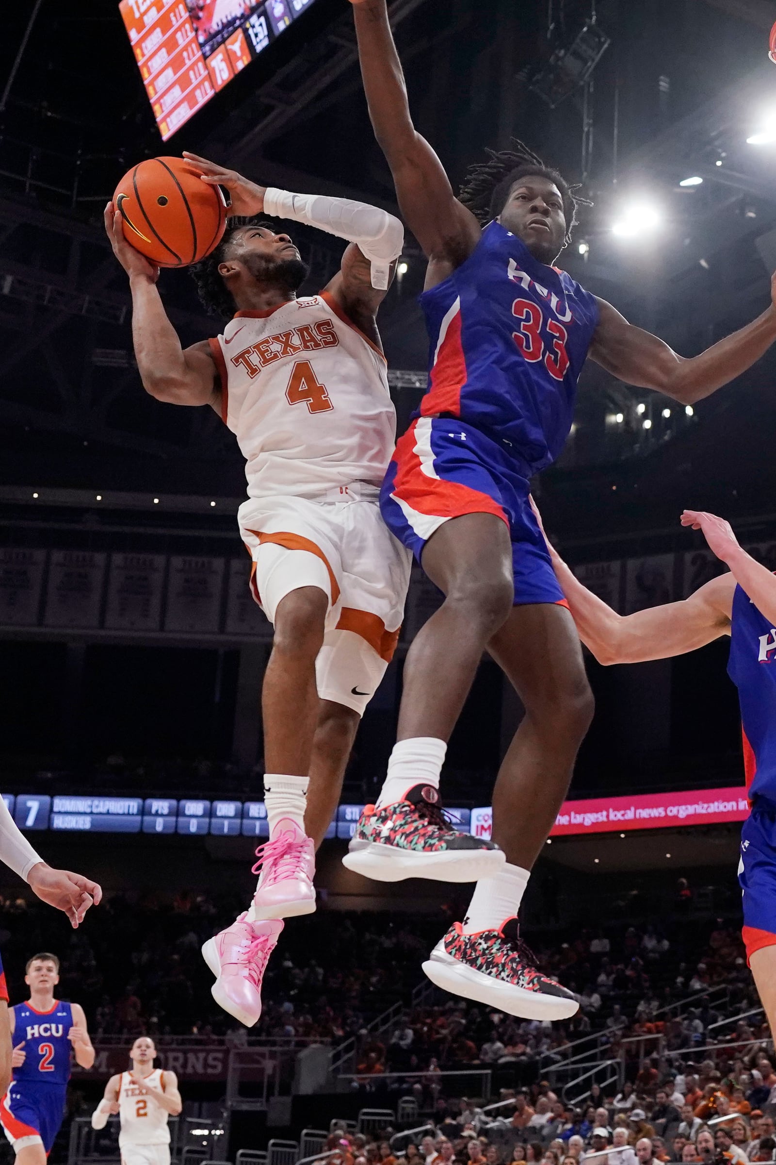 Texas guard Tyrese Hunter (4) drives to the basket against Houston Christian forward Michael Imariagbe (33) during the second half of an NCAA college basketball game in Austin, Texas, Saturday, Dec. 9, 2023. (AP Photo/Eric Gay)