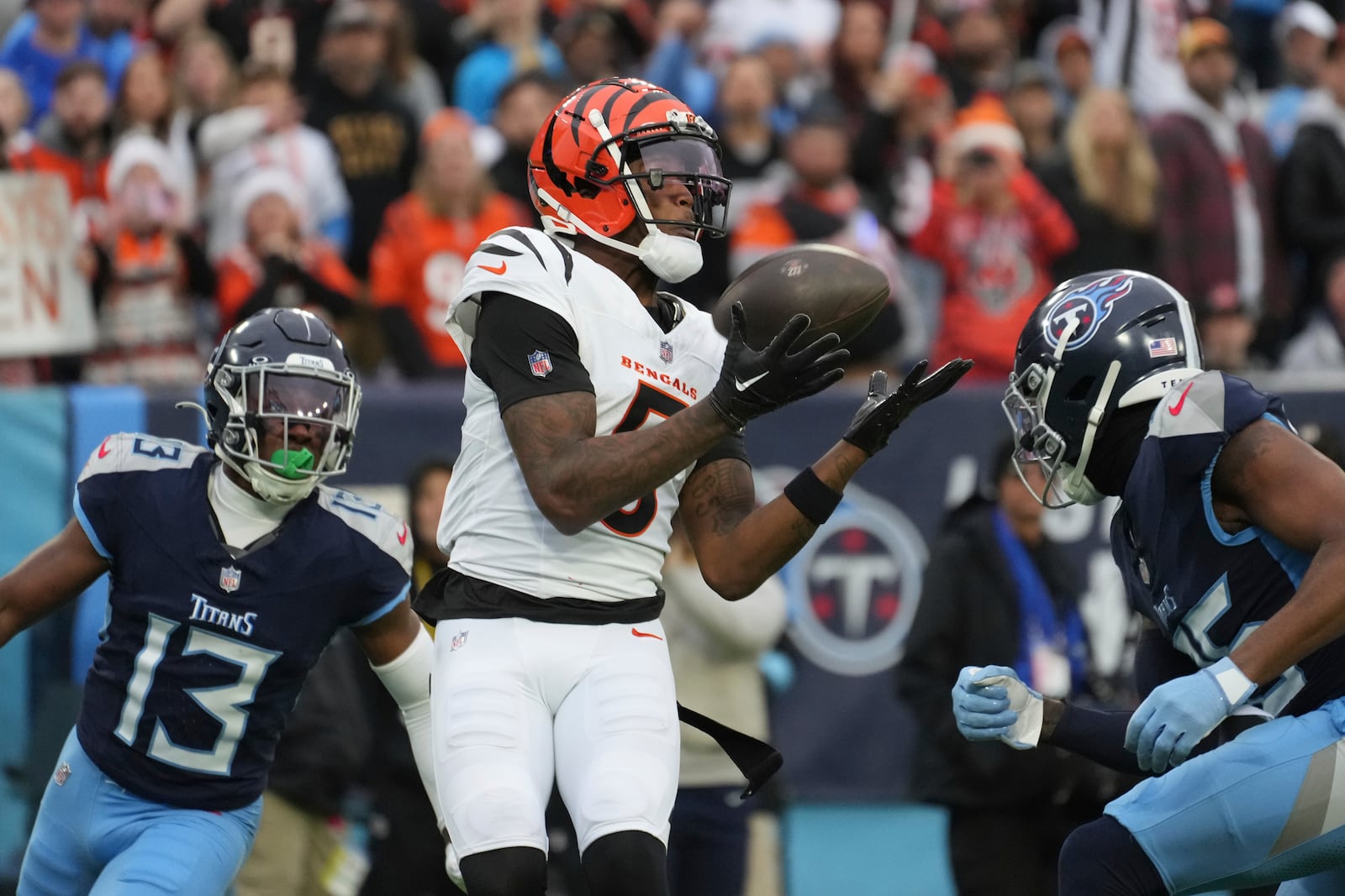 Cincinnati Bengals wide receiver Tee Higgins (5) catches a touchdown pass as Tennessee Titans cornerback Chidobe Awuzie (13) and cornerback Daryl Worley, right, defend during the first half of an NFL football game Sunday, Dec. 15, 2024, in Nashville, Tenn. (AP Photo/George Walker IV)